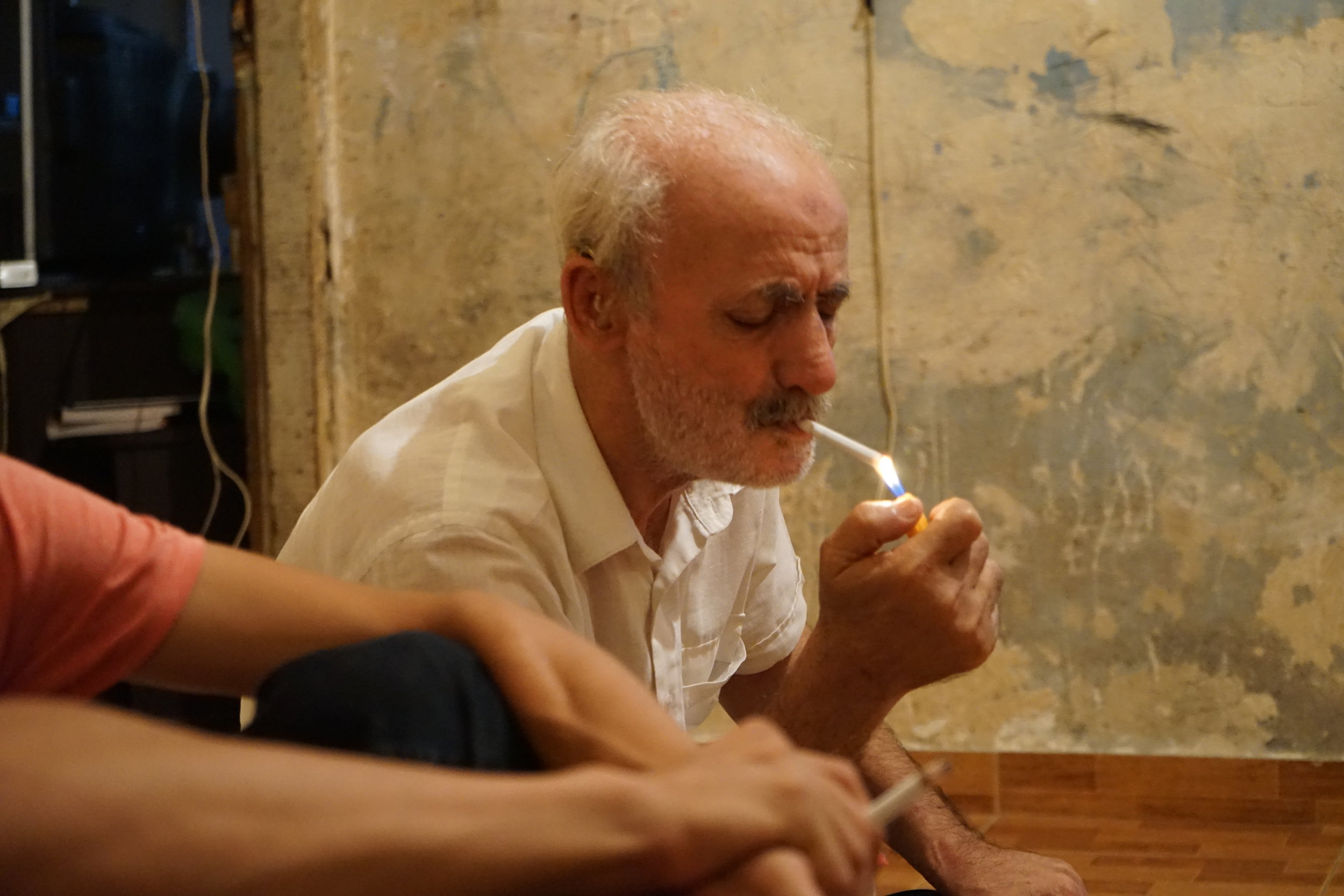  Ahmad Mohamad Ghanam lights a cigarette in his home in Sabra and Shatila on August 17, 2016. 