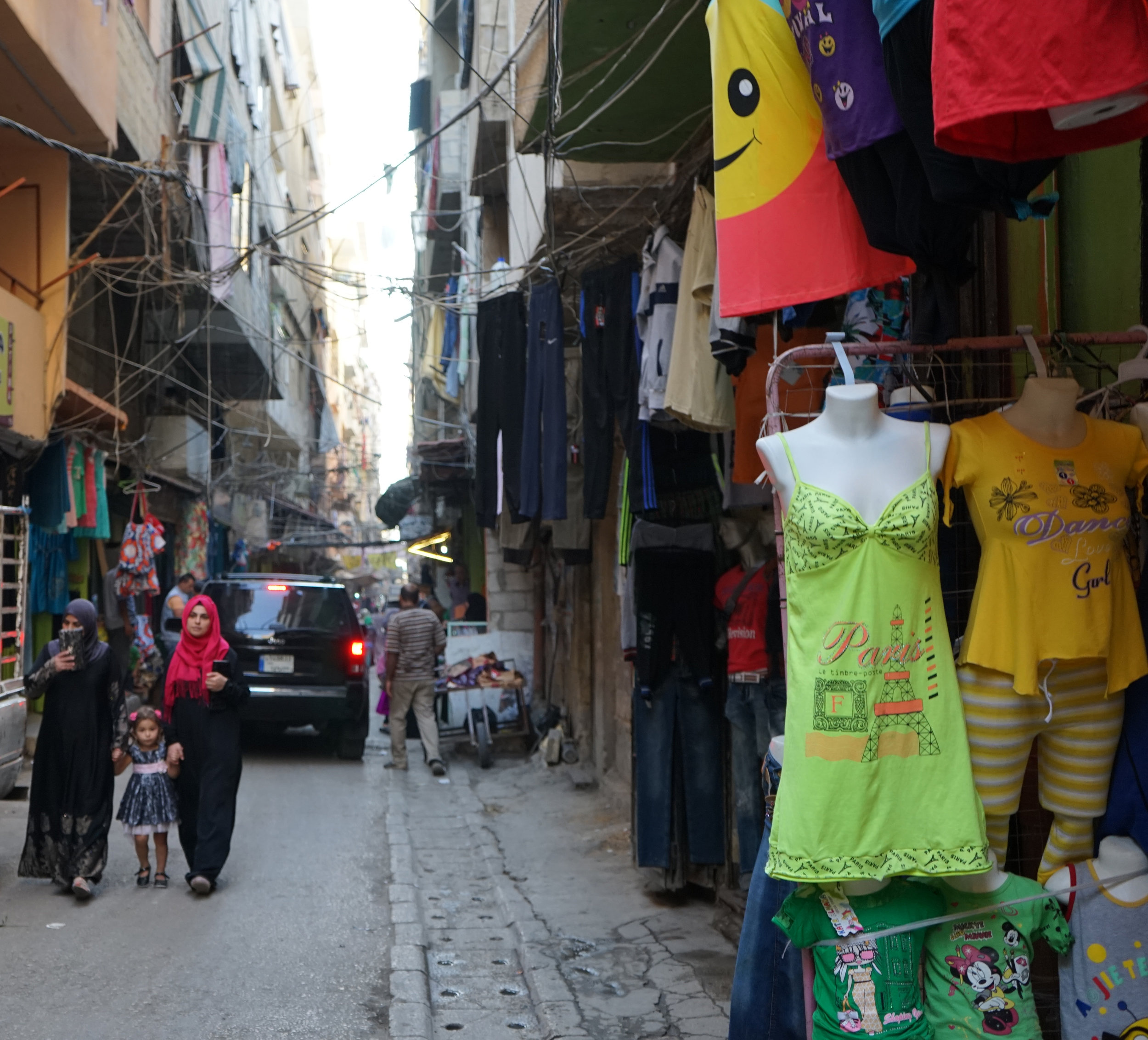  Two women walk past a store selling lingerie in Camp Beddawi on August 20, 2016. 