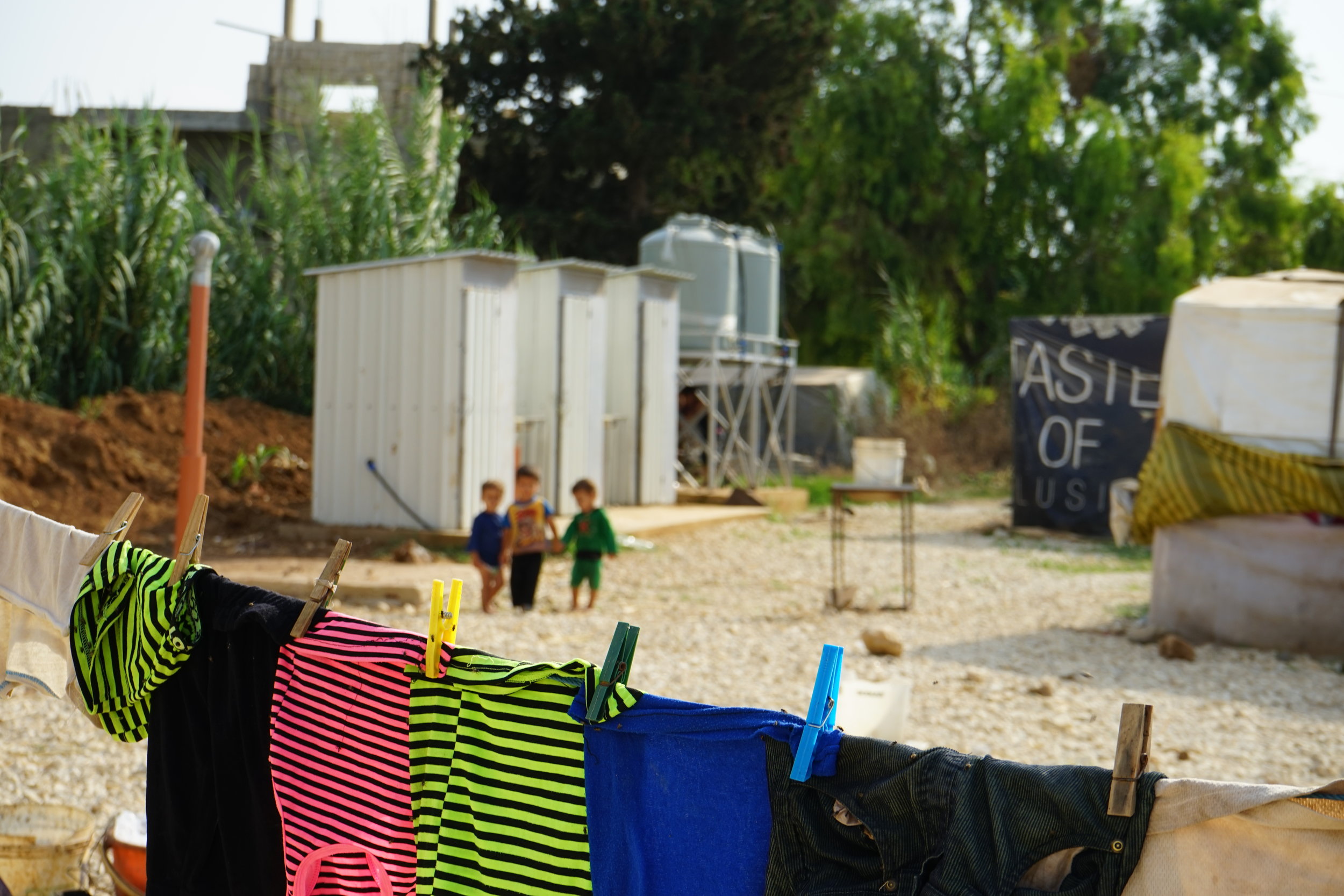  A group of children walk through a UNHCR Syrian refugee camp in 'Akkar, Lebanon on August 23, 2016. 