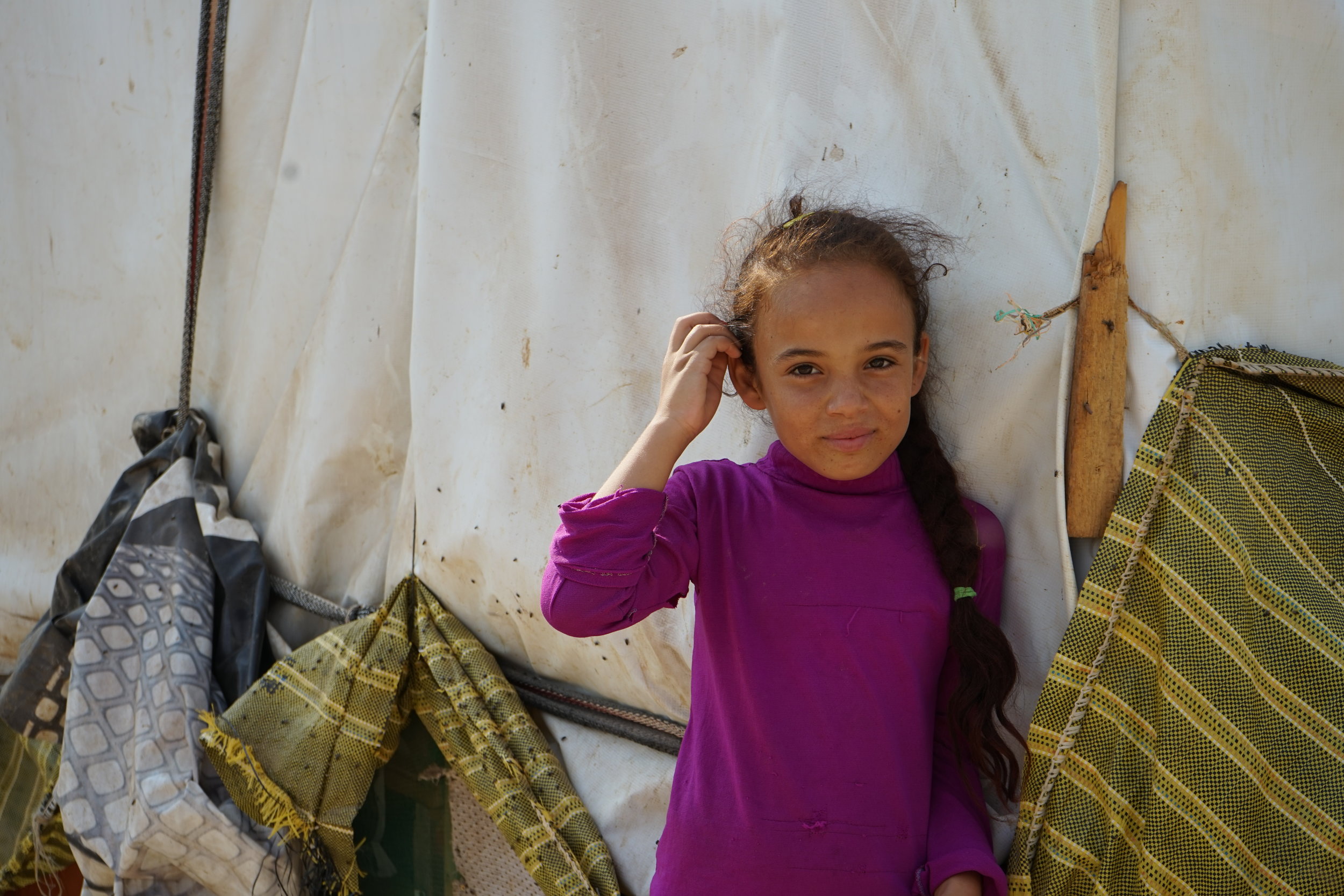  A girl stands outside a tent in a UNHCR Syrian refugee camp in 'Akkar on August 23, 2016. 