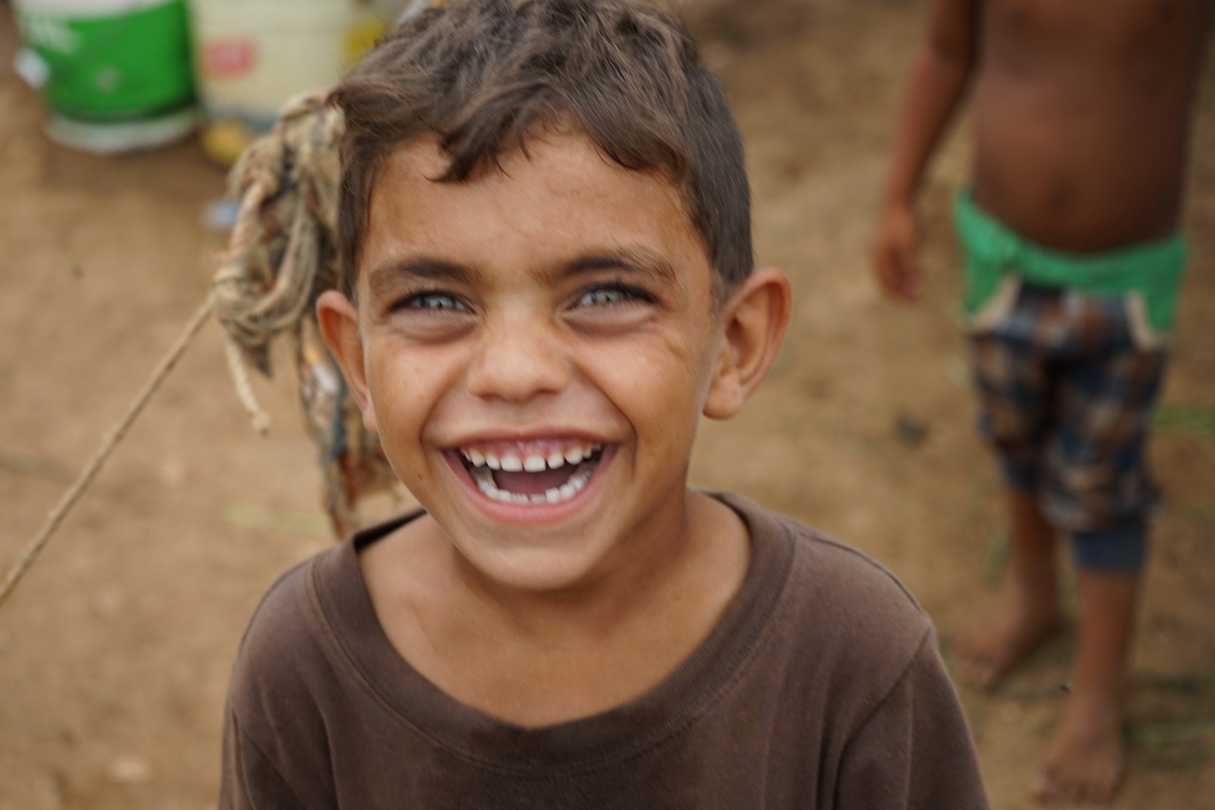  A young boy cracks up in UNHCR Syrian refugee camp 054 in 'Akkar on August 24, 2016. 