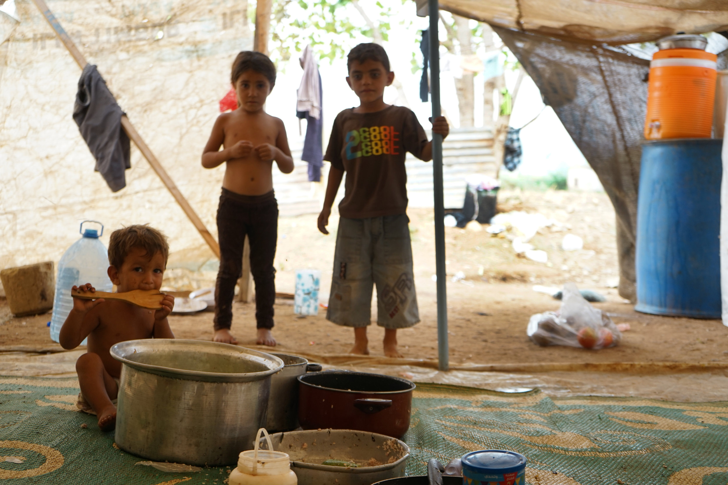  Children snack on traditional Middle Eastern food in a tent in UNHCR Syrian refugee camp 054 in 'Akkar on August 24, 2016. 