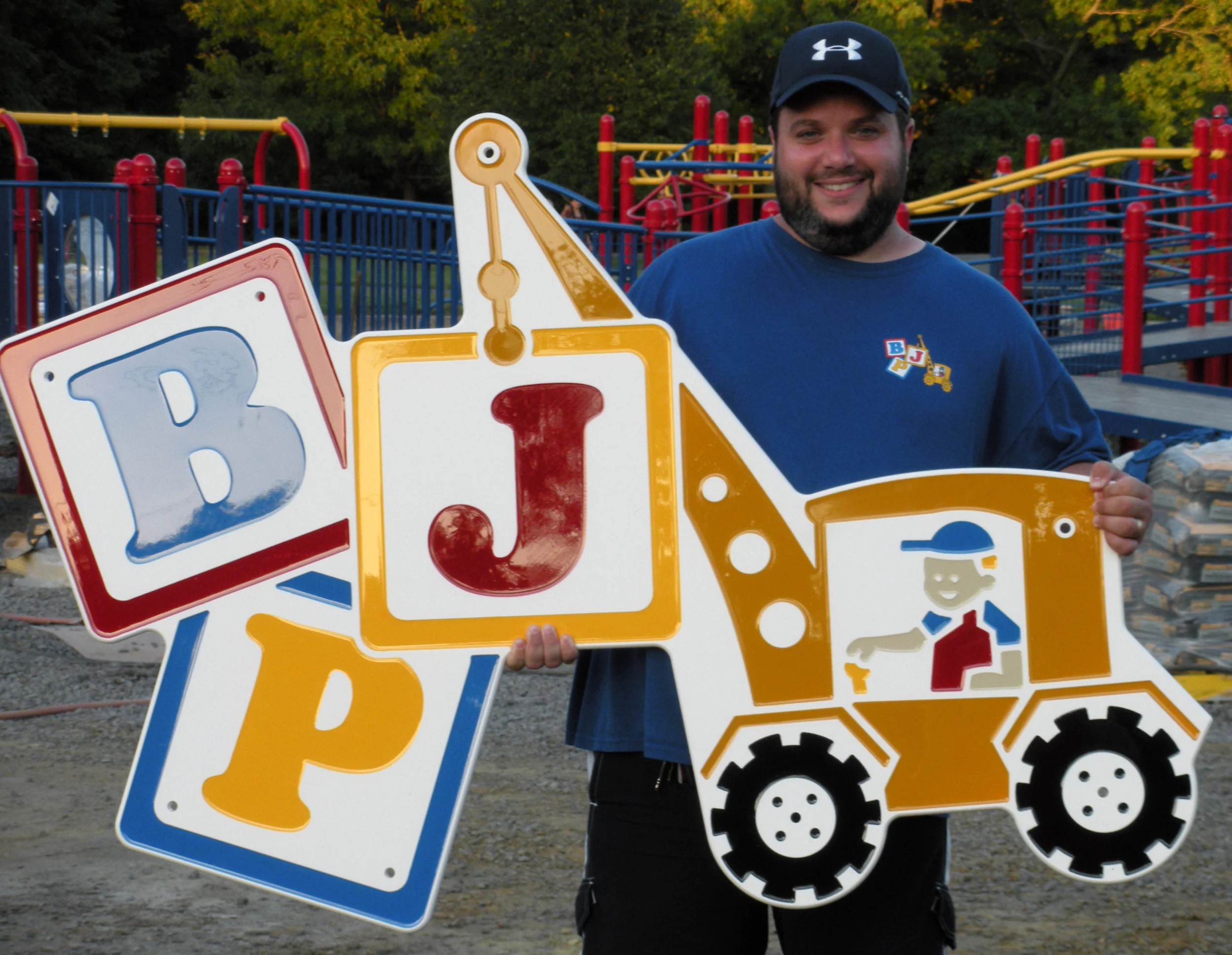 During the 3-day playground community build, Joseph Nasto (Co-Founder/President) holds the BJP logo that goes atop the archway leading to Jake's Place.