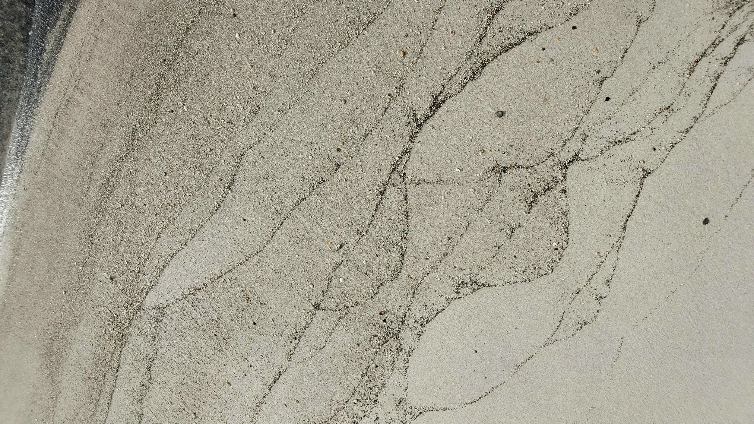  While communing with God in His creation during my walk on a deserted Gulf Shores beach, I noticed these fine “etchings” in the sand. They’re actually tiny bits of shell and other organic matter left on the sand by various tides and waves. What a fa