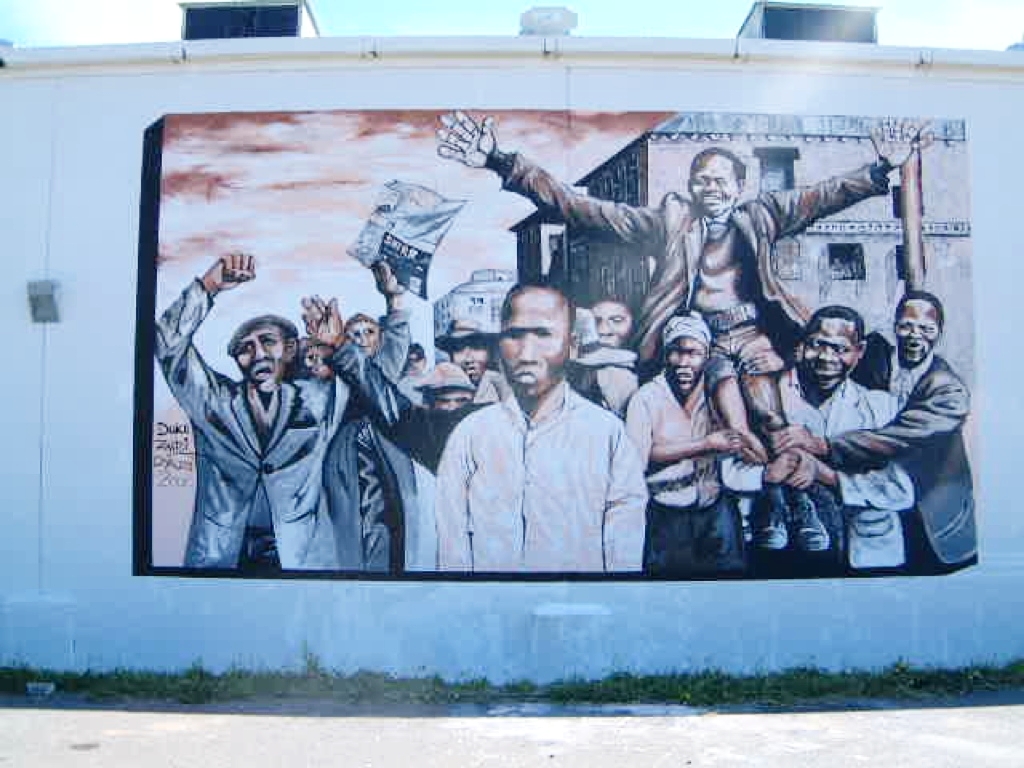 Ricky Dyaloi, Duke Norman, Timothy Zantsi with Roger Van Wyk - mural project for Returning the Gaze in Langa, commemorating the Philip Skosana led anti pass law march, based on a famous photograph of Skosana being carried. 