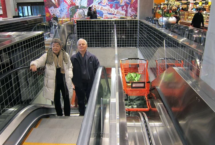 Mum and dad ride up the escalator with their newly-adopted cart.