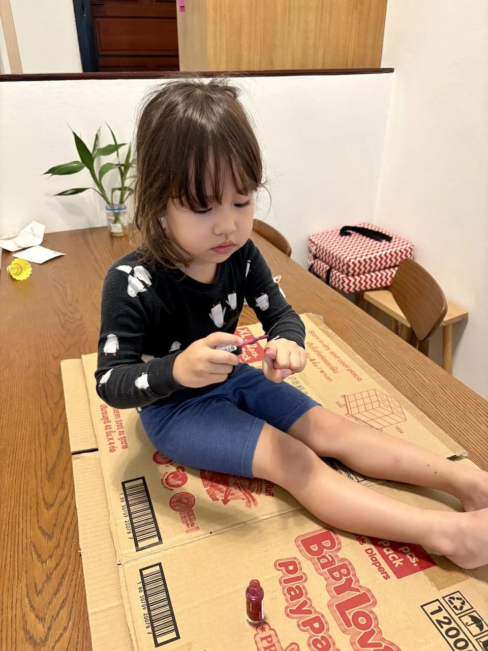 Painting her own nails & toe nails.