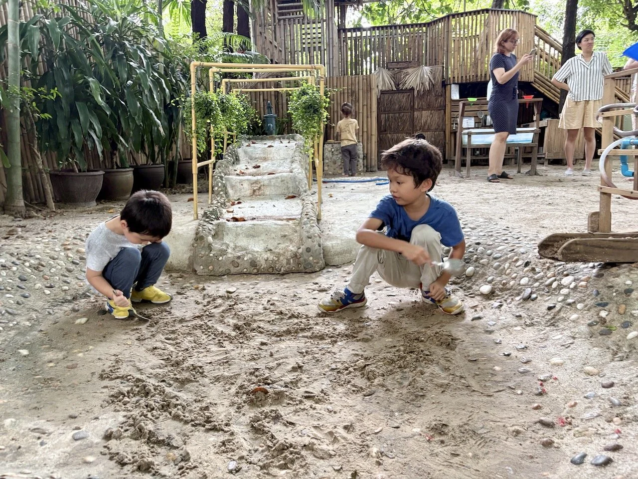 Busy workers Arlo and Fuku, helping Teacher Mhel scrape the sand out of the pond.