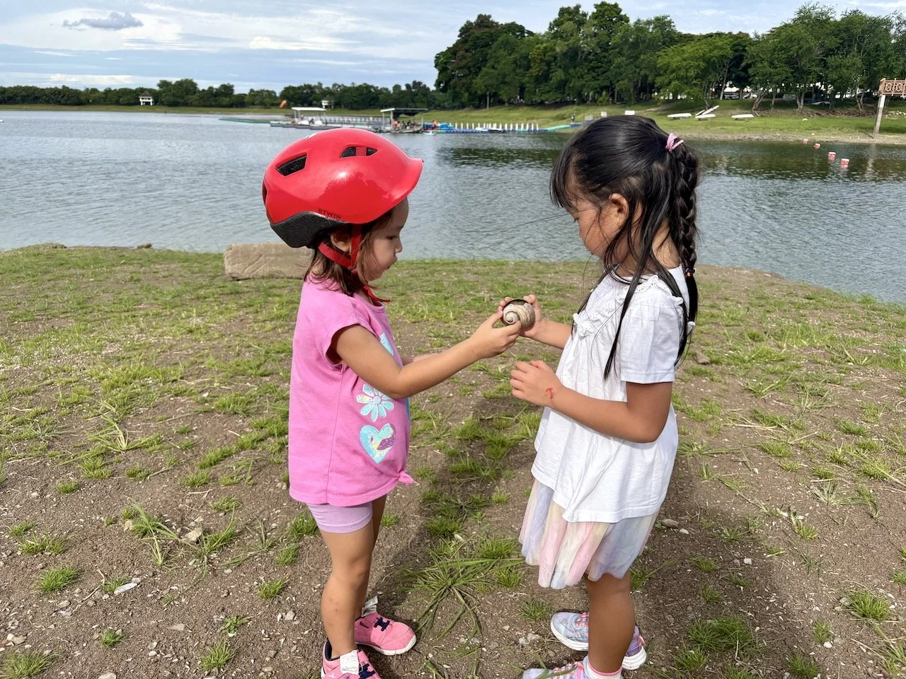 Lucy and Aya checking out a giant (fresh water?) shell they found.