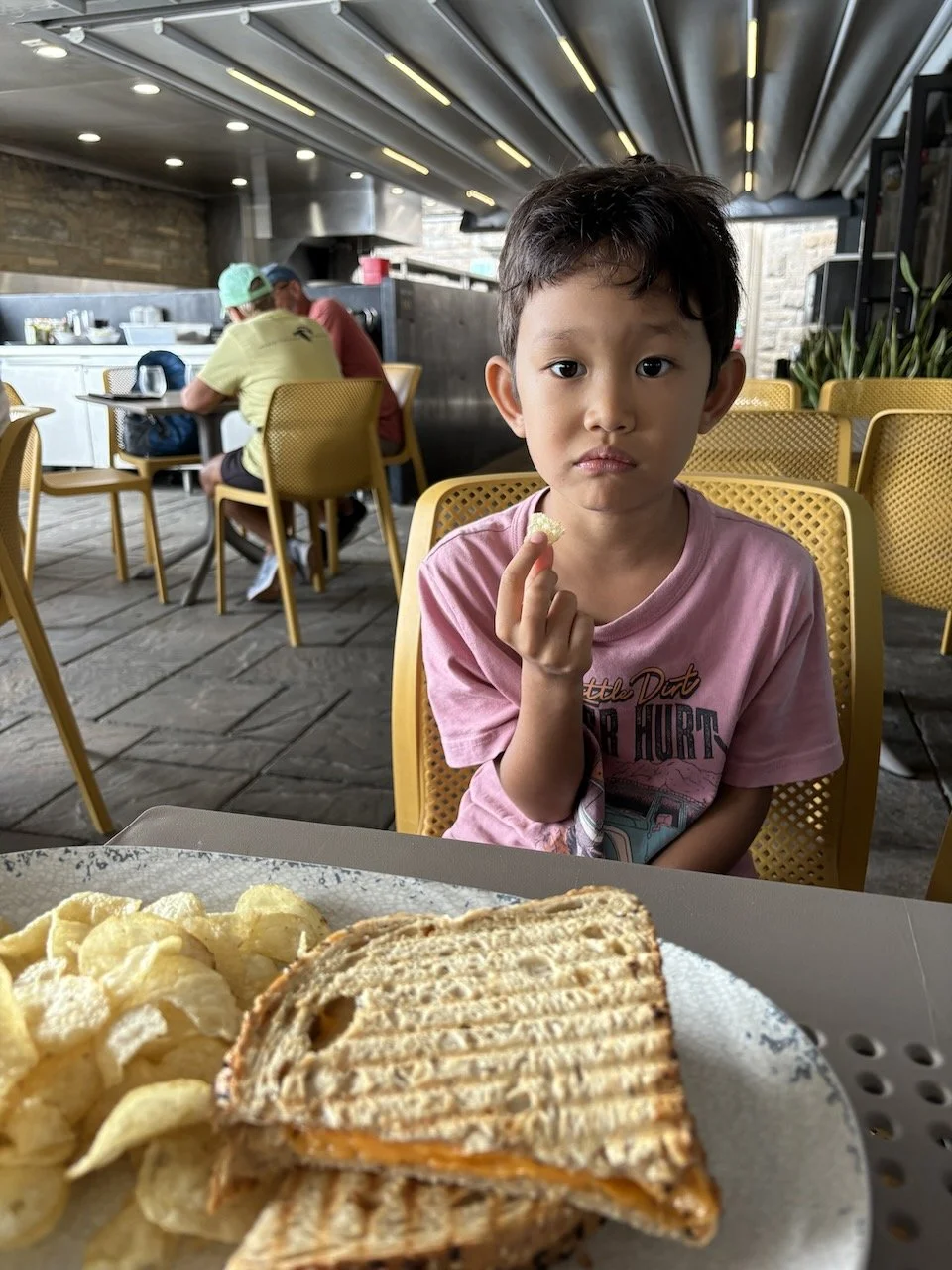 Very unenthusiastic about his delicious lunch (with a view).