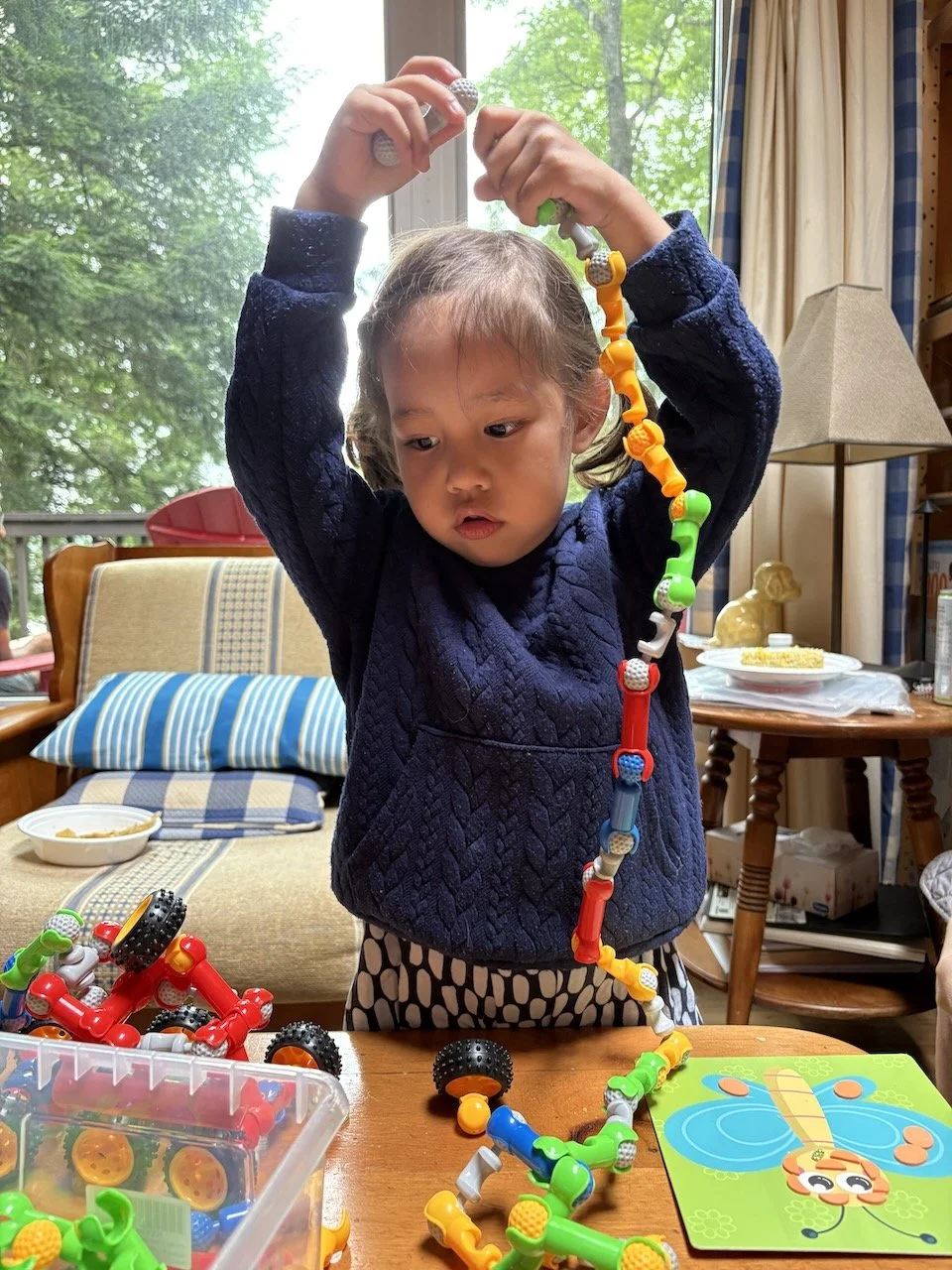 Lucy's concentrating hard on making this contraption taller than herself.