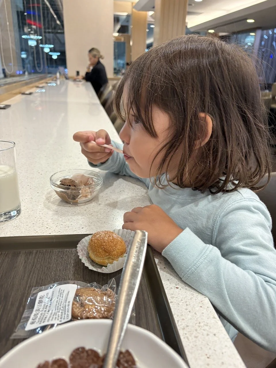 Lucy, enjoying a second breakfast of Haagen-Dazs in the lounge with Mum.