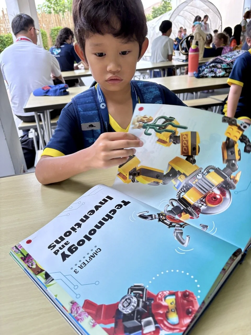 Today, he checked out a book all about Lego creations, and is reading it while waiting for his teacher to show up.