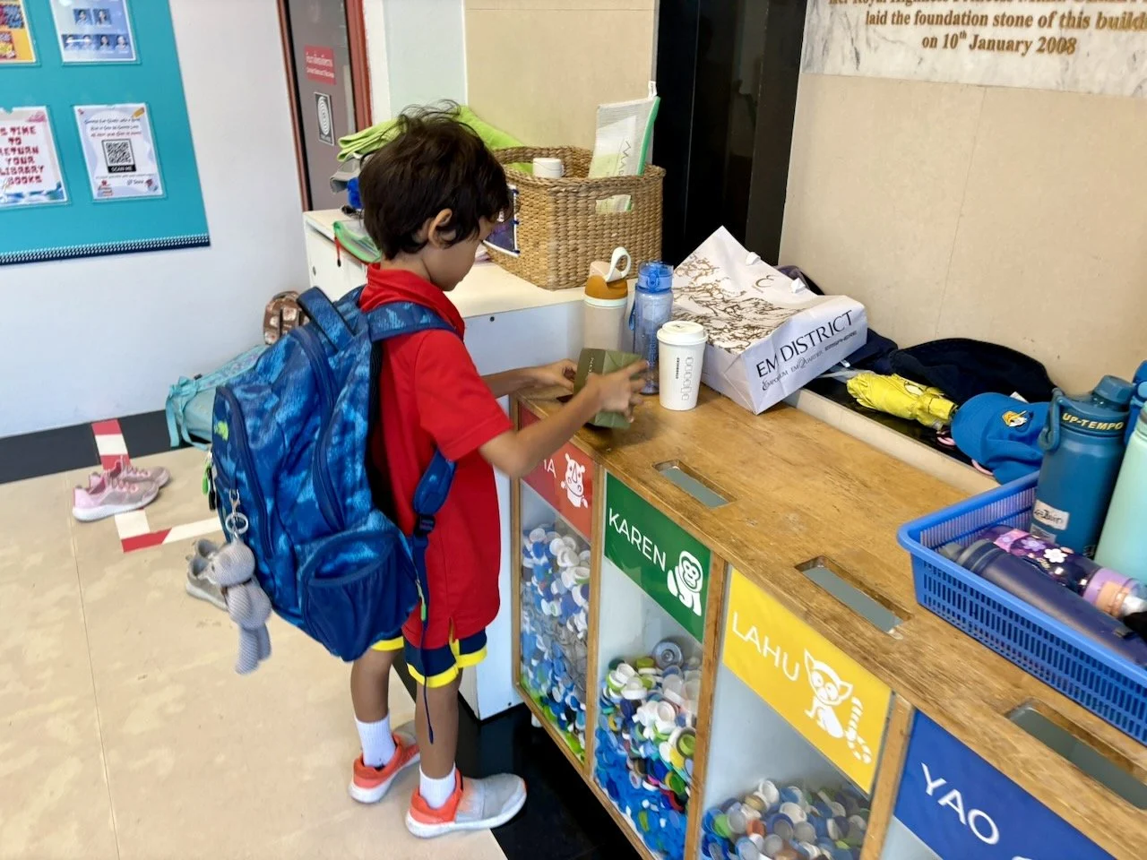 Depositing his bottle caps, for house points.