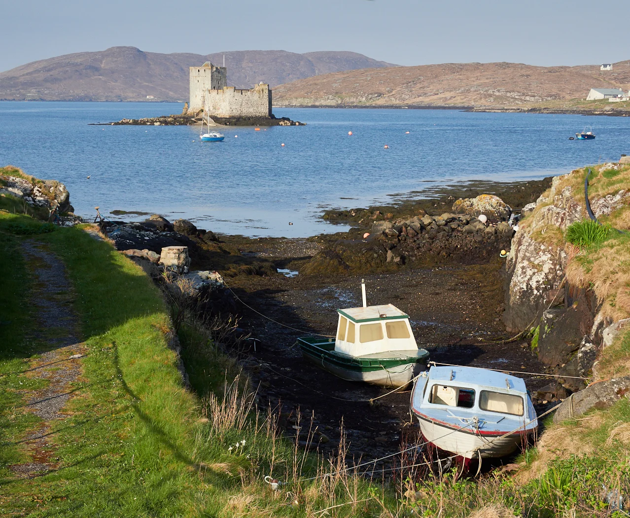 Kisimul Castle from the outskirts of Castlebay, with Vatersay in the distance
