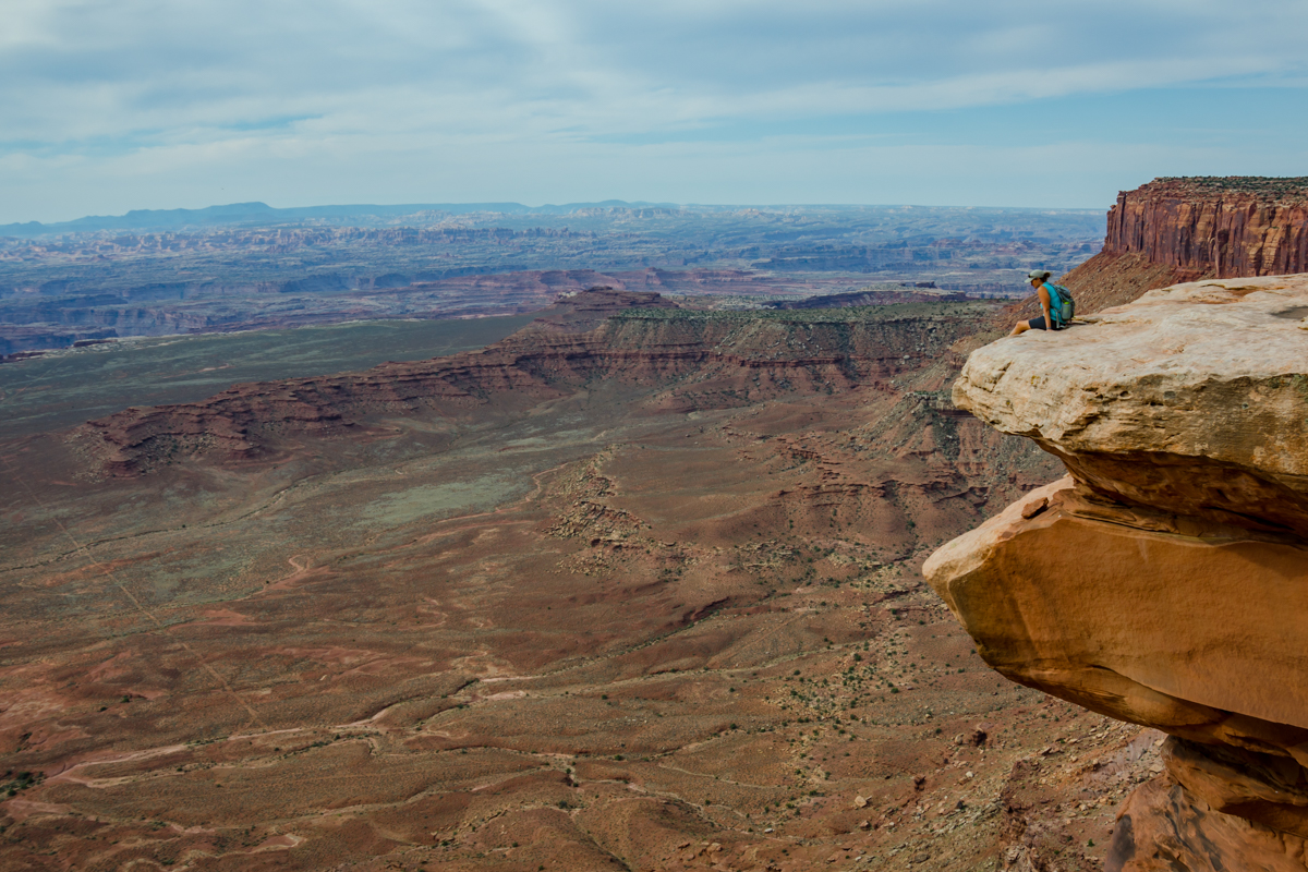 Female Hiker Looks Down Over Grand View in Island in the Sky