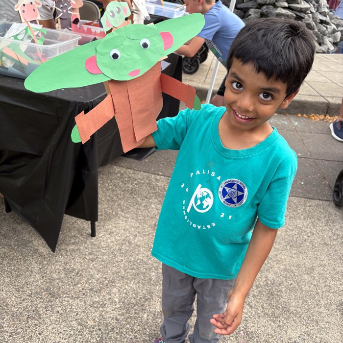 Young boy with handmade puppet at ACLO event