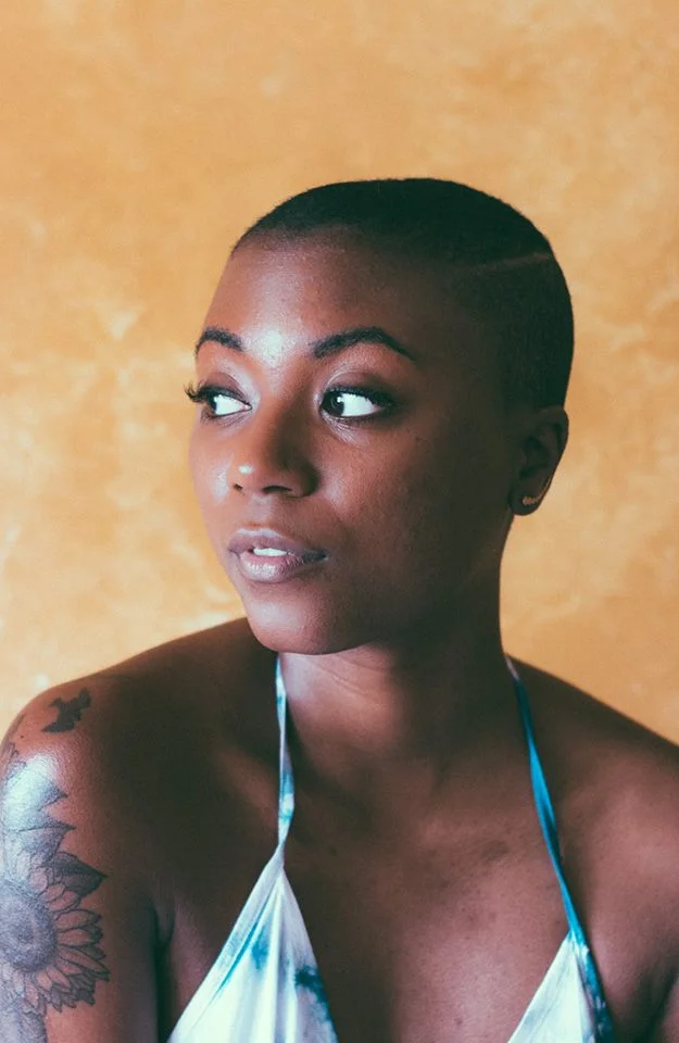 black-woman-arm-tattoo-orange-background.jpg