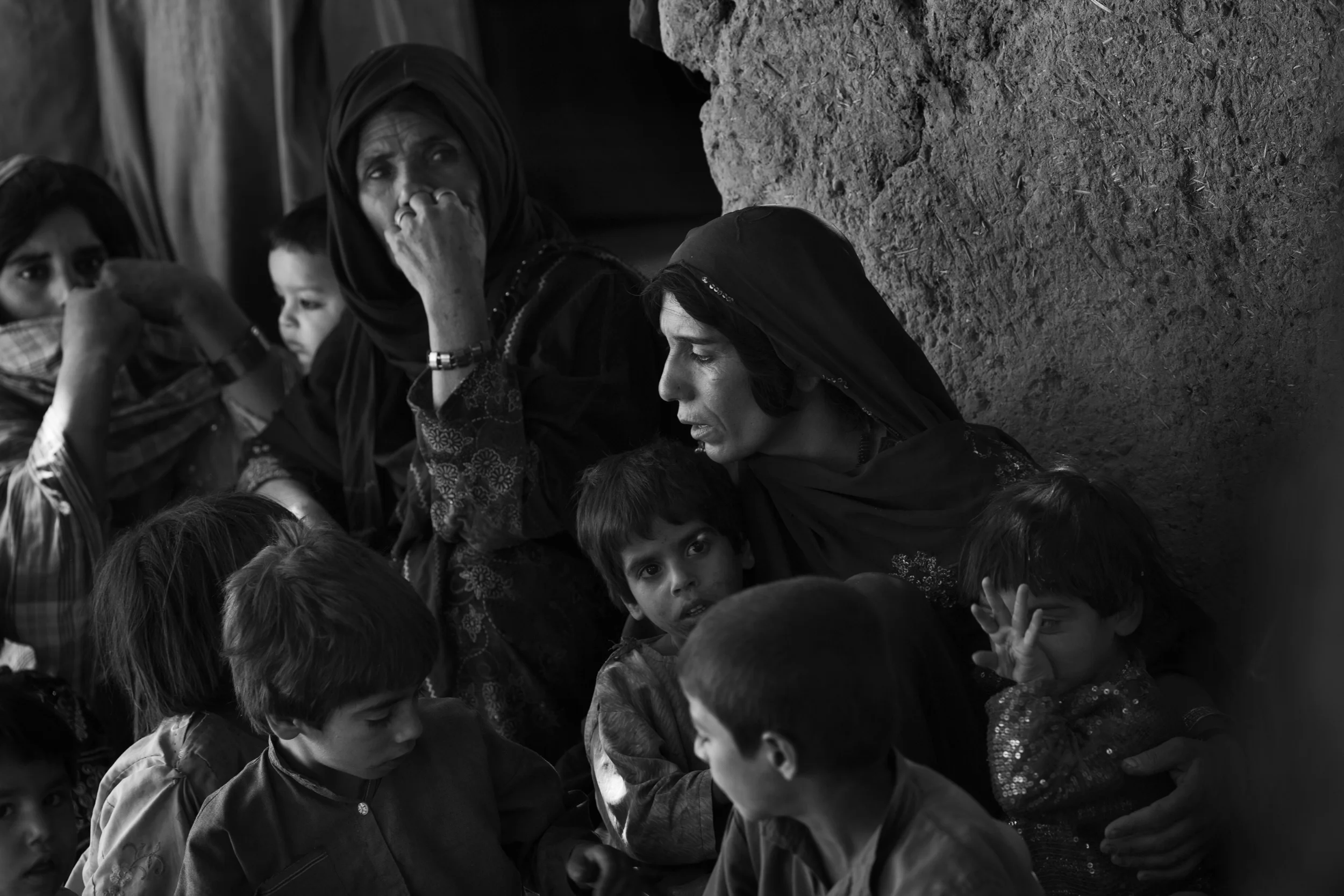  Women and children gather as Marines search their compound, Helmand. 