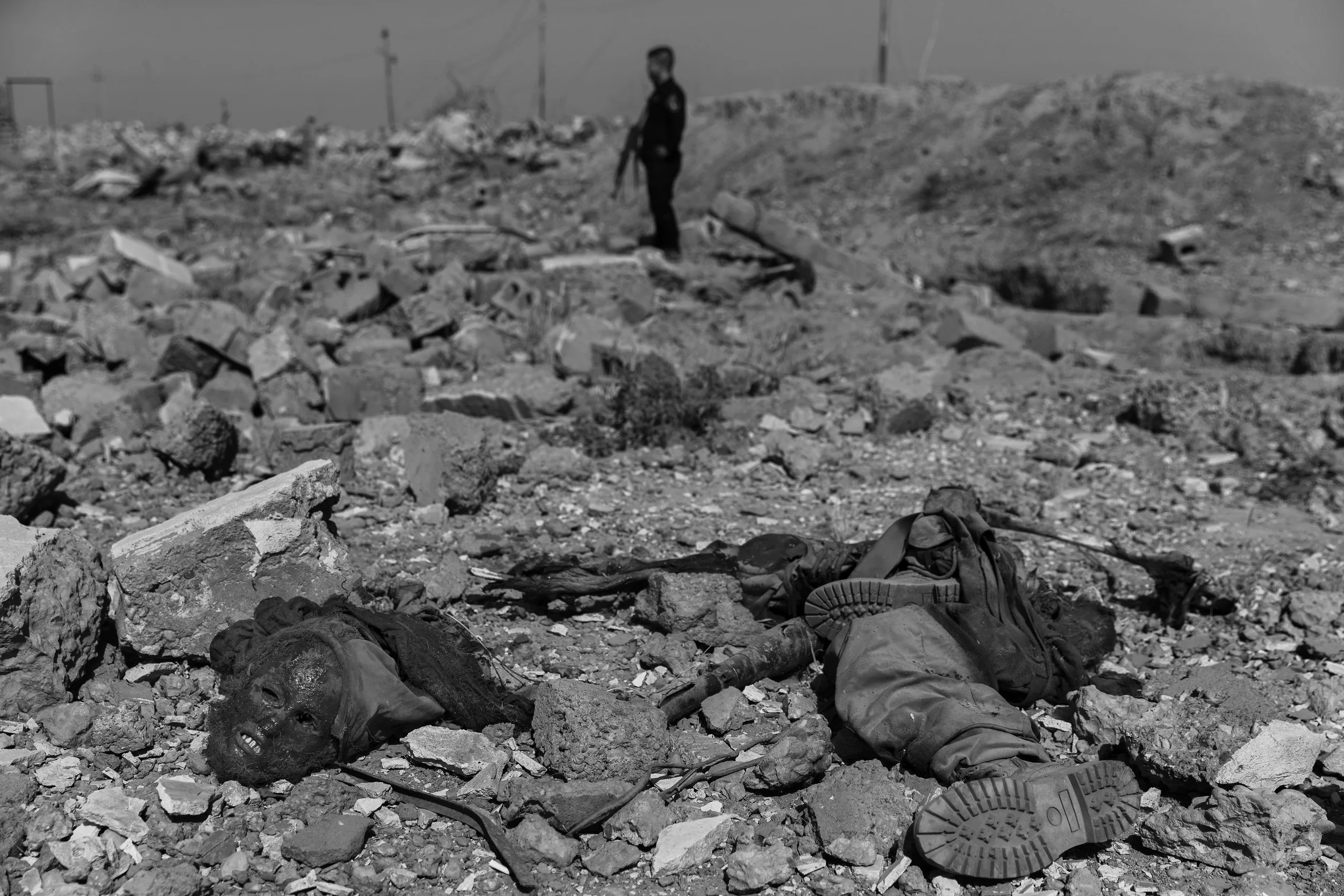  Rudwan walks past the body of an ISIS fighter killed in an airstrike,&nbsp;Khrbadan, near the Makhmour front. 