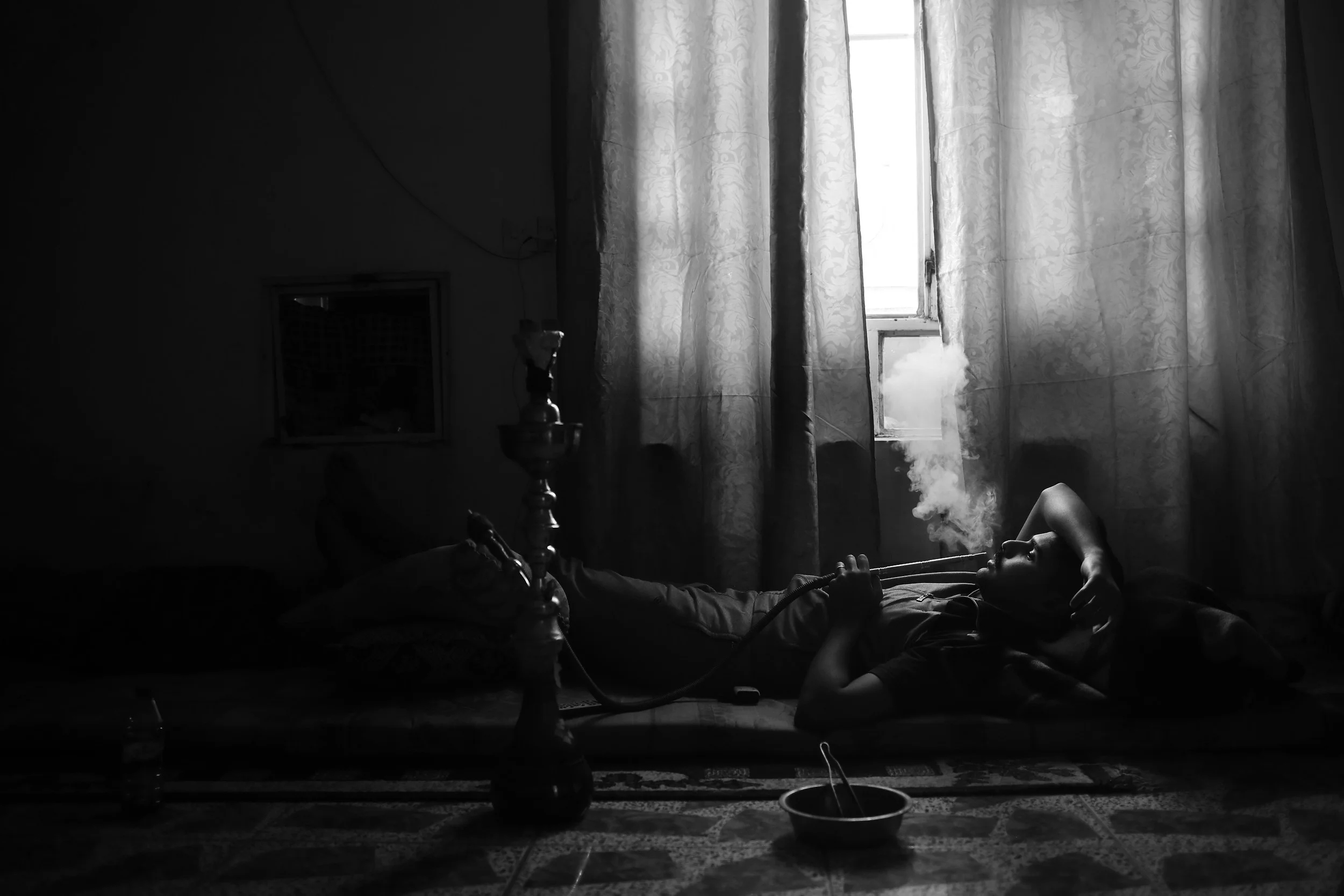  Lt. Saad smokes a hookah, waiting for orders to join the fight for Mosul, at a base in Mahana. 