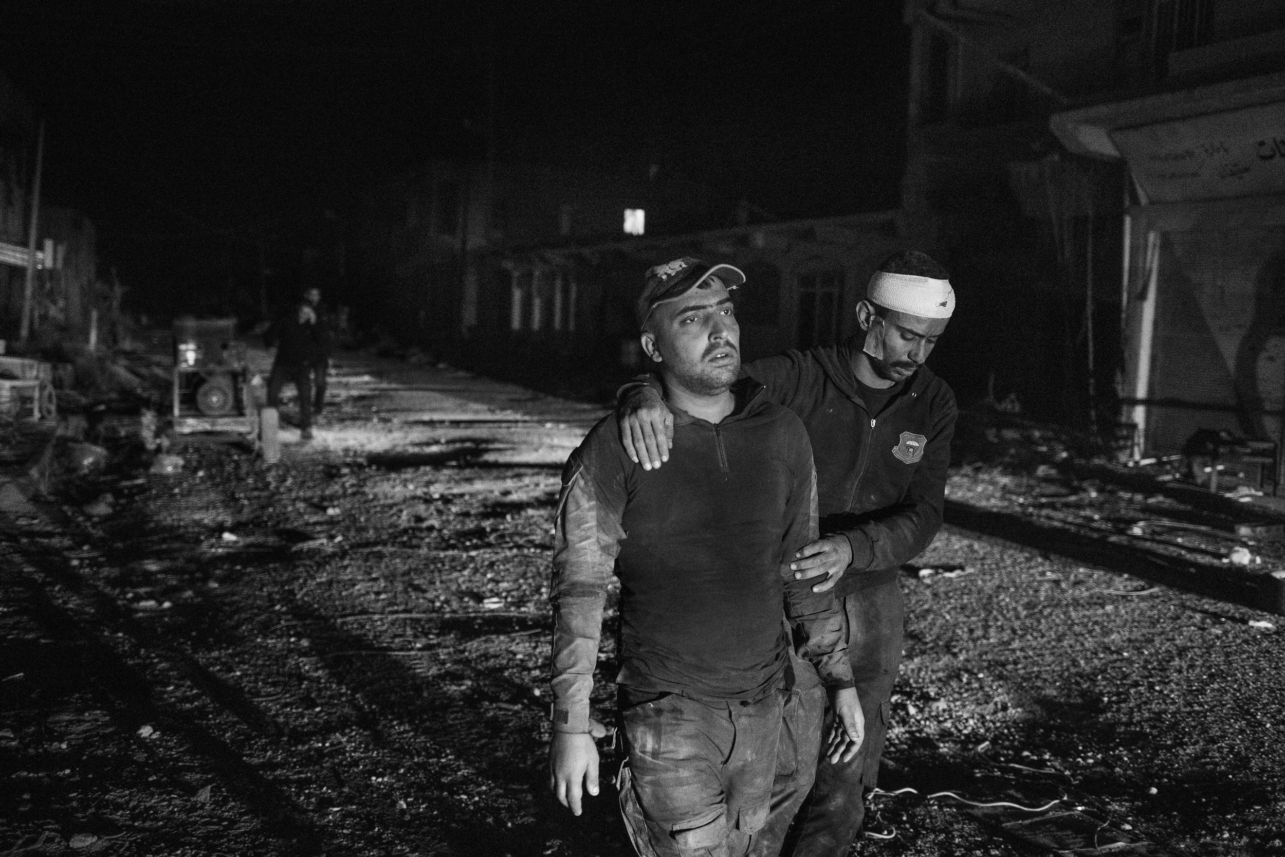  Cpl.&nbsp;Ehab Rafa leads Sgt. Dombuk to be evacuated for his injuries after they withdrew from the fighting in Mosul. 