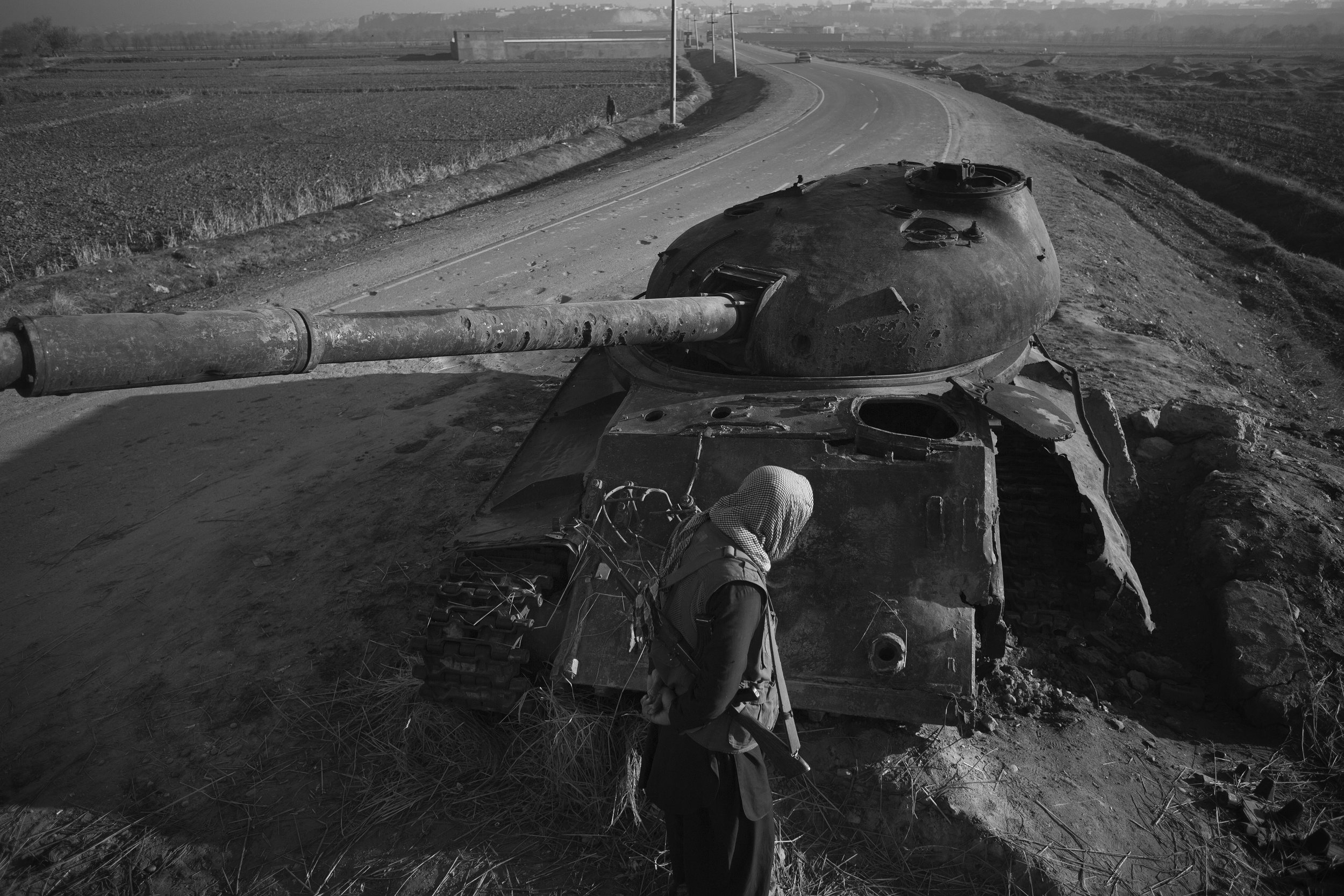  Militiaman guards a tank, stolen by the Taliban and destroyed by US air power. 