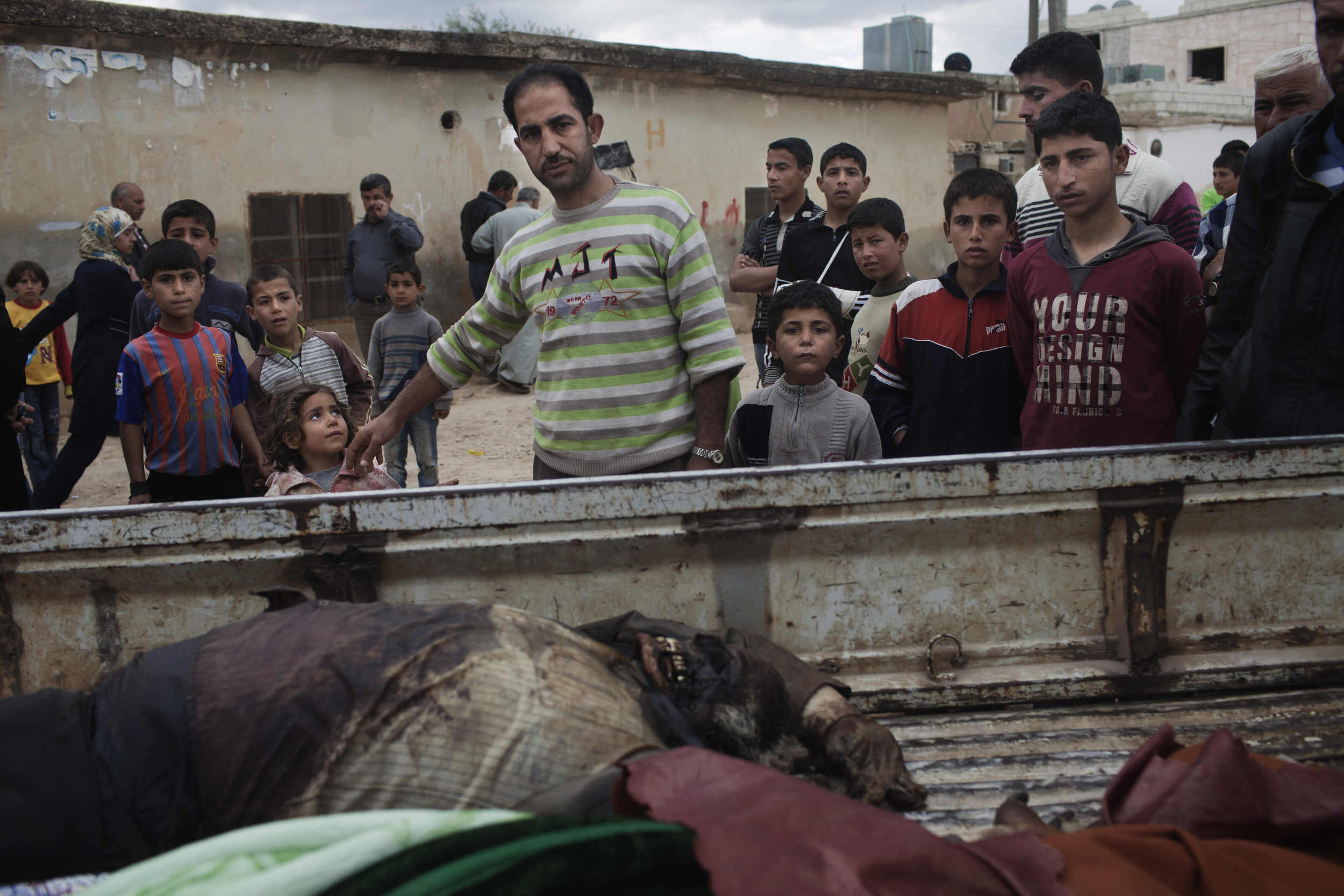  Friends and neighbors look over the body of Jamil Setoot, killed by the Syrian army, Taftanaz. 