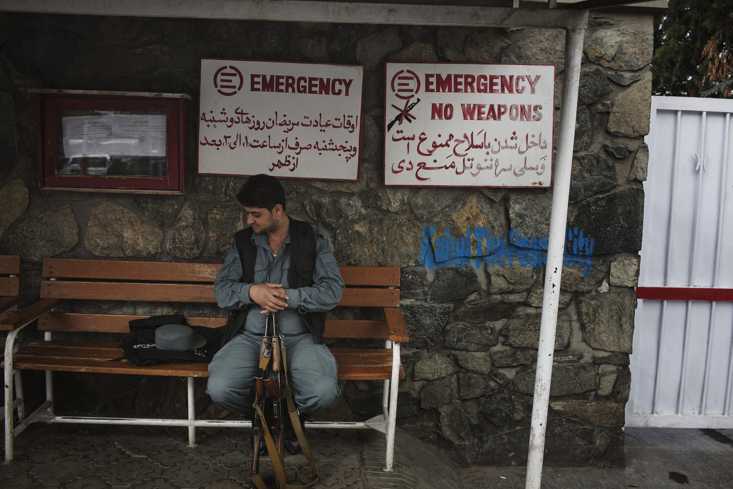  An Afghan policeman waits with his companions weapons, prohibited inside the hospital.&nbsp; 
