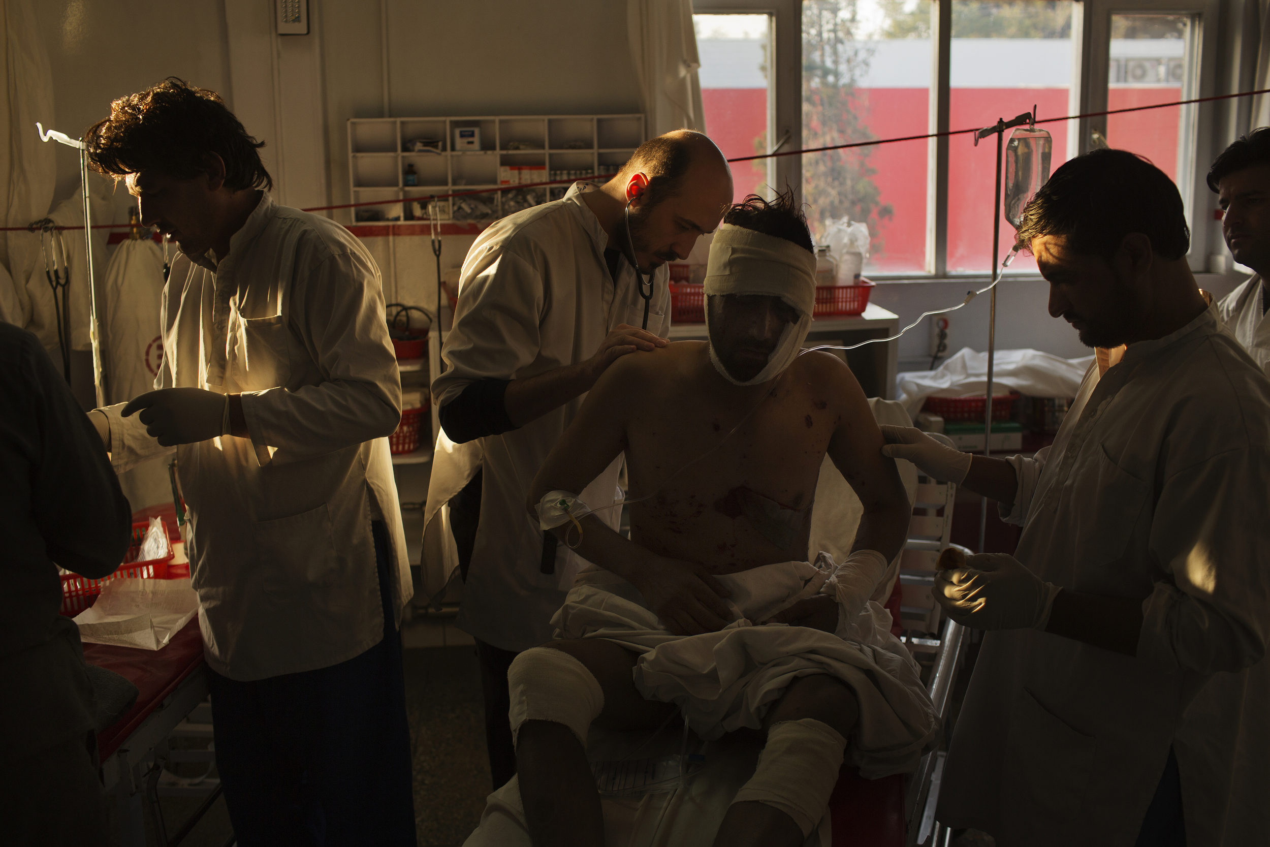  Surgeon Daniel Scerrati, center, examines Jamat Gul, 28, who suffered shrapnel injuries in an IED blast 
