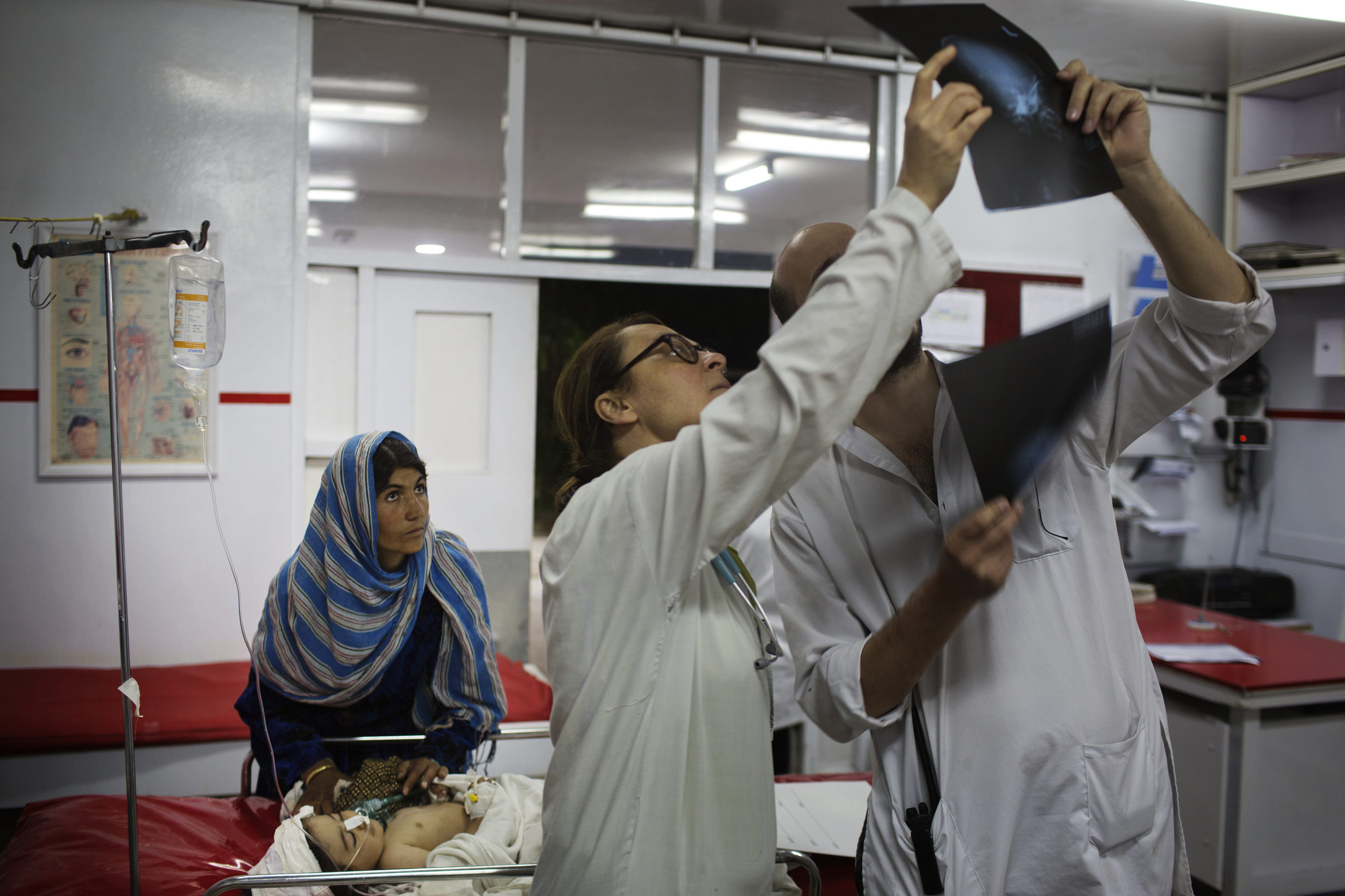  Emergency doctors look over the X-rays of Nasirullah, 1, who suffered a shrapnel injury to her head in Ghazni. 