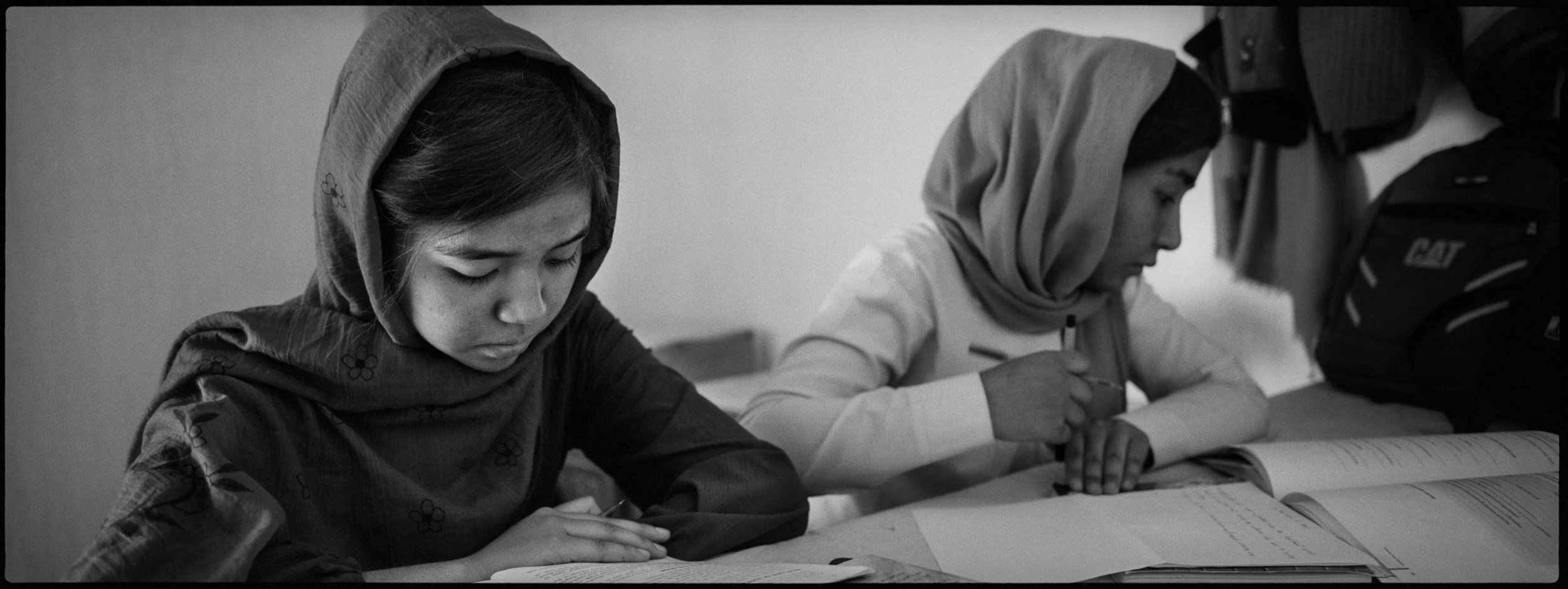  The Ahmadi sisters, banned from studying in high school, work on their English homework, Dasht-i-Barchi. 