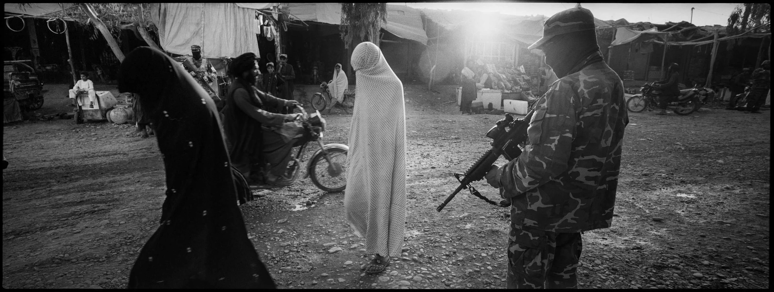  Women walk the main street in Musa Qala.  