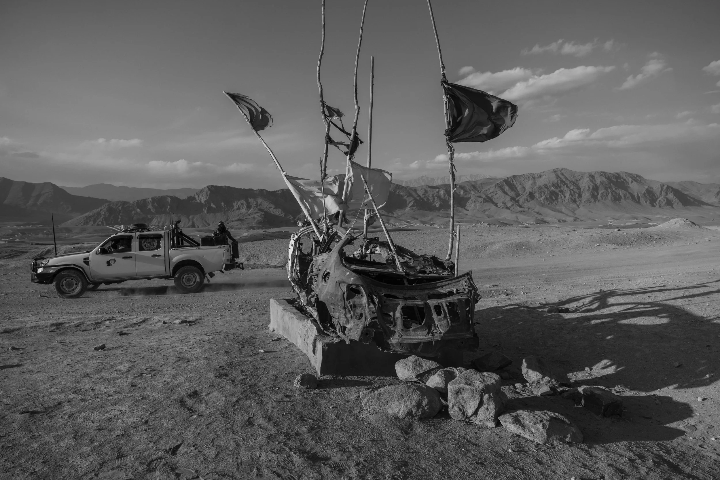  A Taliban pickup passes a drone memorial, Wardak. 