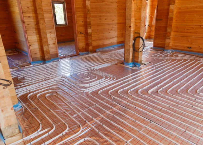 How does radiant heat flooring work and what are the two common types?
