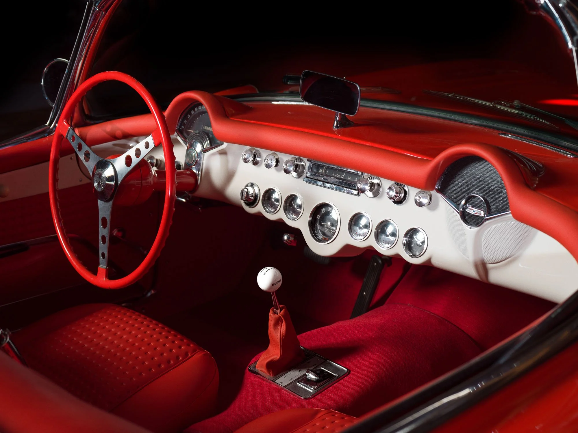 Red dashboard and steering wheel inside a vintage sports car