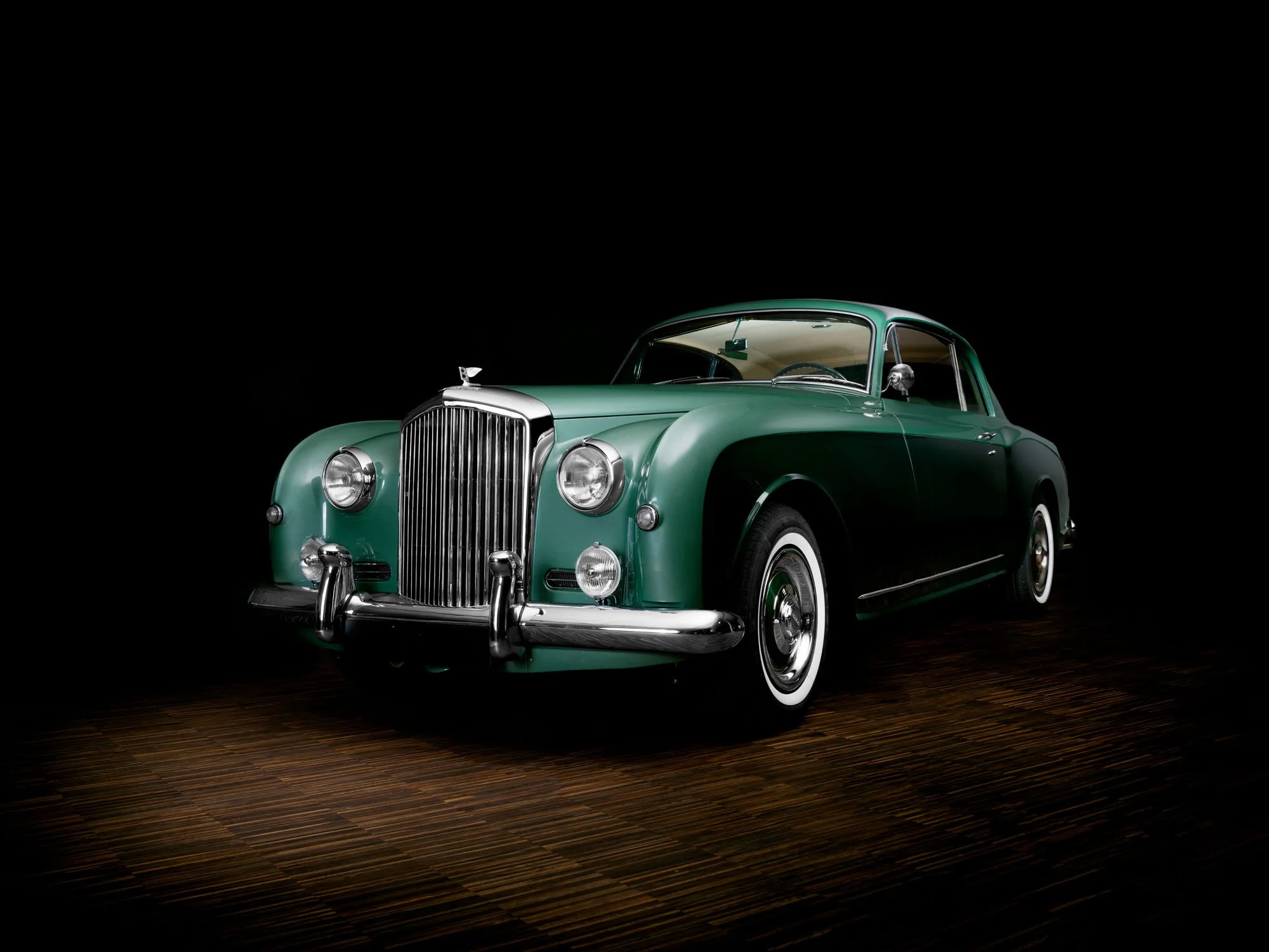 Vintage green car photographed on a dark studio set