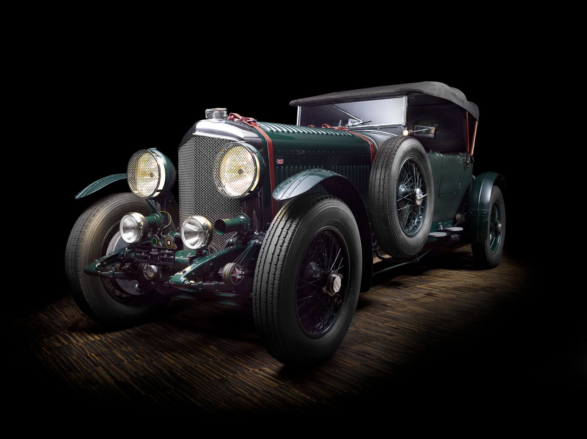 Vintage green racing car photographed against black