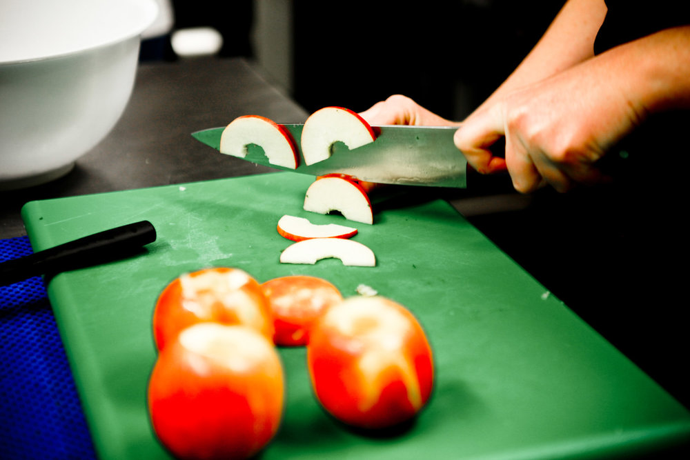 Cored apples being chopped on a chopping board