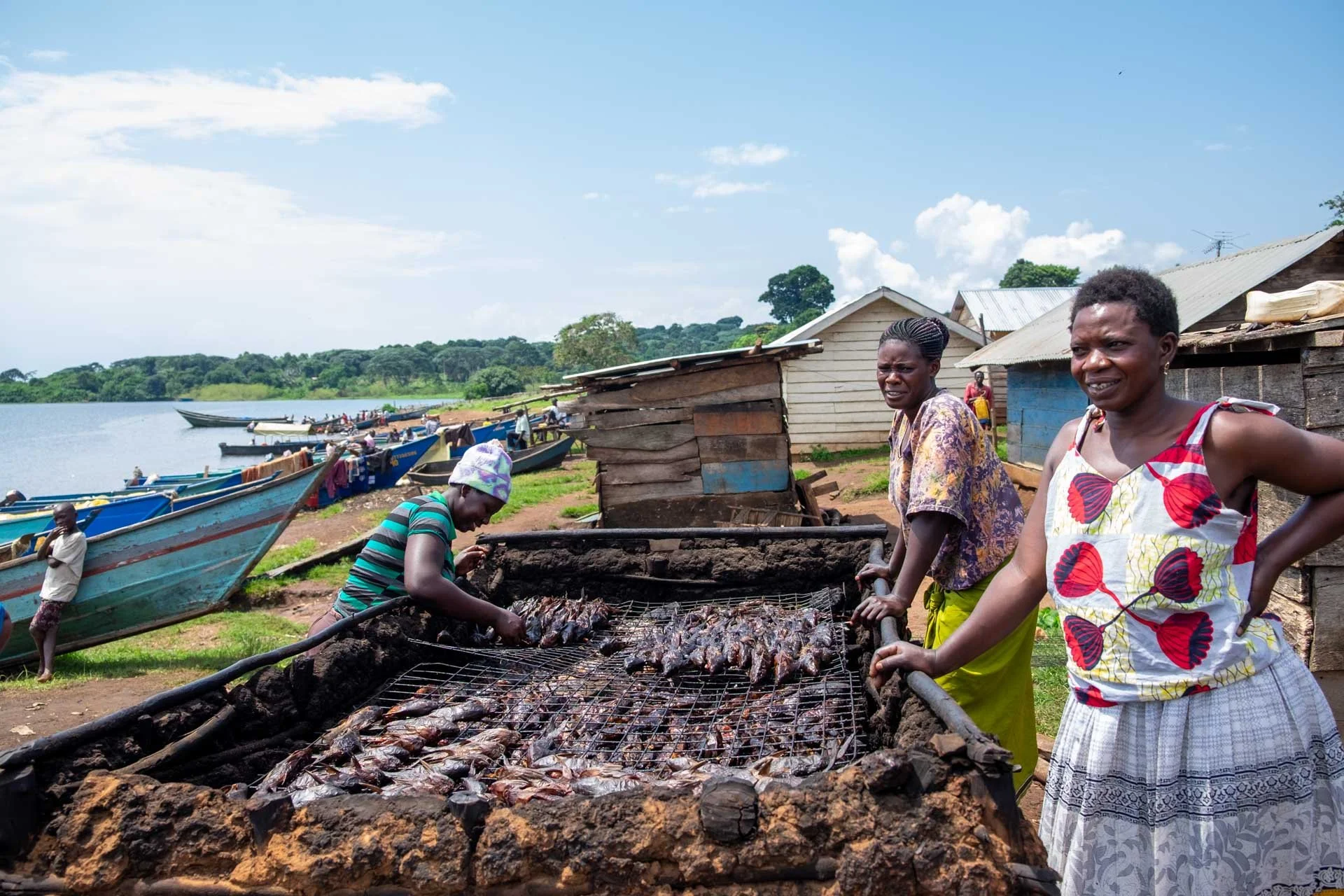 Fishing village on the shores of Lake Malawi with villagers drying and harvesting small fish along the lakeside