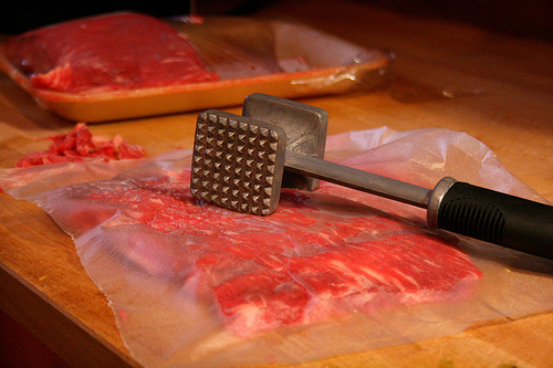 raw meat with mallet