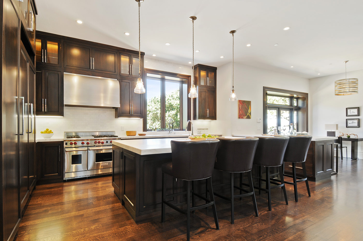 ktichen, cabinetry, hardwood floors, wolf stove, marble counters, barstools, kitchen pendant, stainless steel range