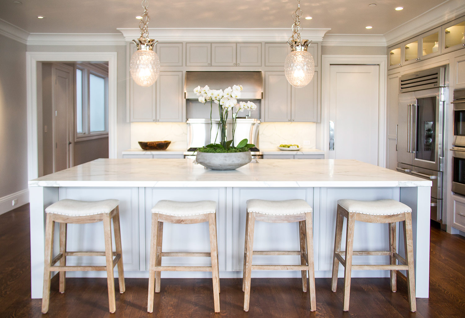 kitchen, white, marble, simple, lighting, counters, stainless steel, appliances, backsplash, barstools, hardwood floor, cabinets 