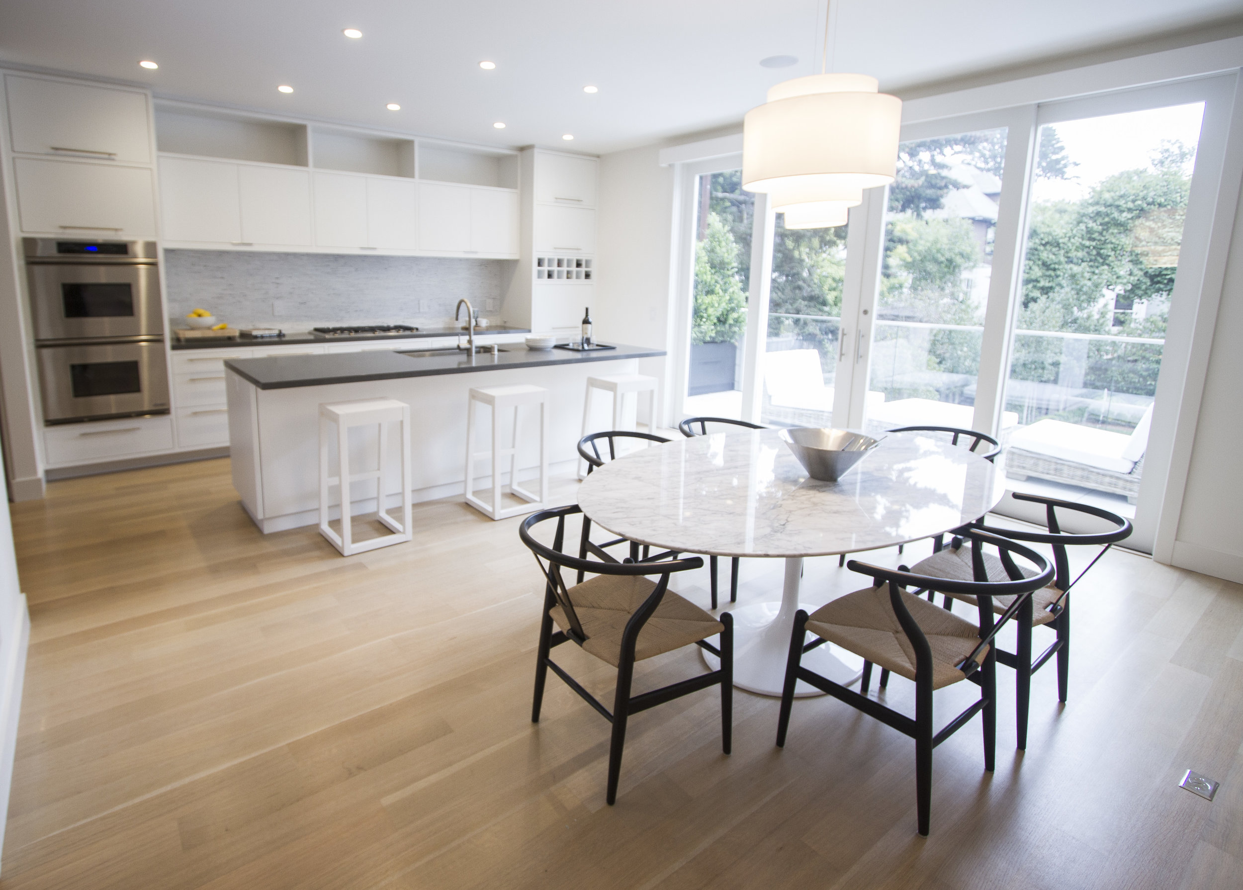 white kitchen, marble backsplash, modern, simple, overhead lighting, bar stools, chandelier, 