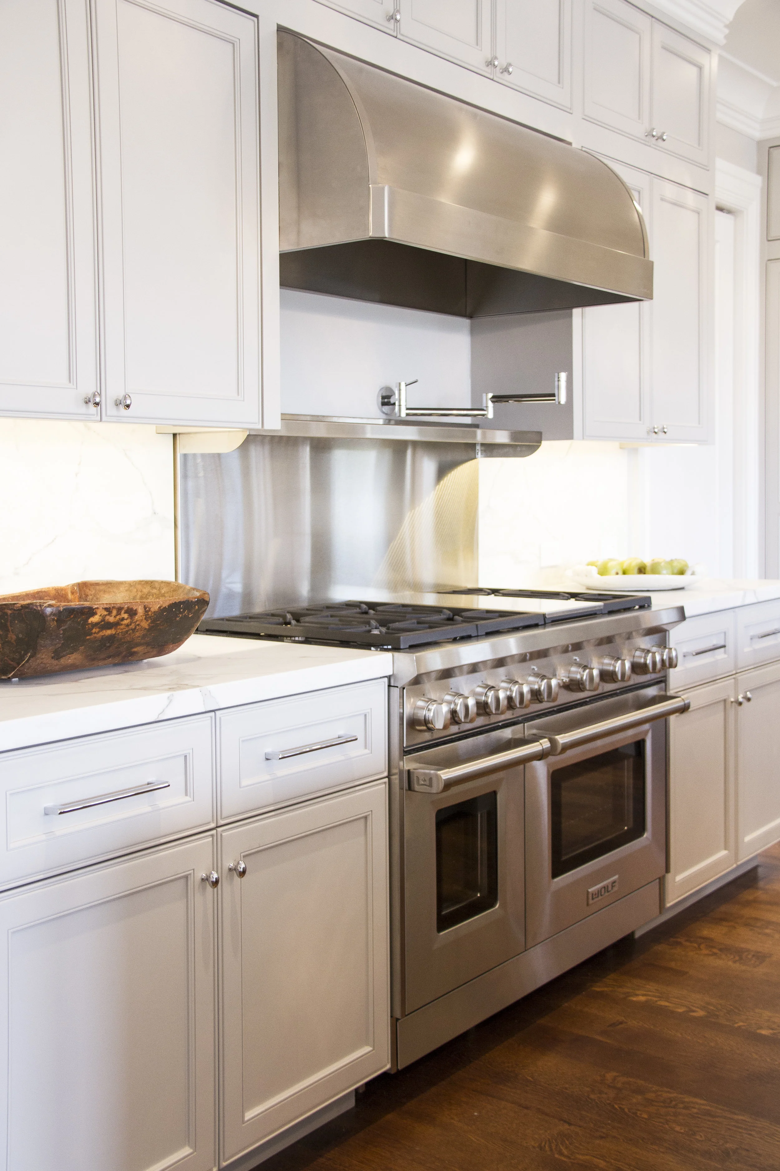 kitchen, white, oven, stainless steel, hardwood floor, marble counters, neutral cabinets 