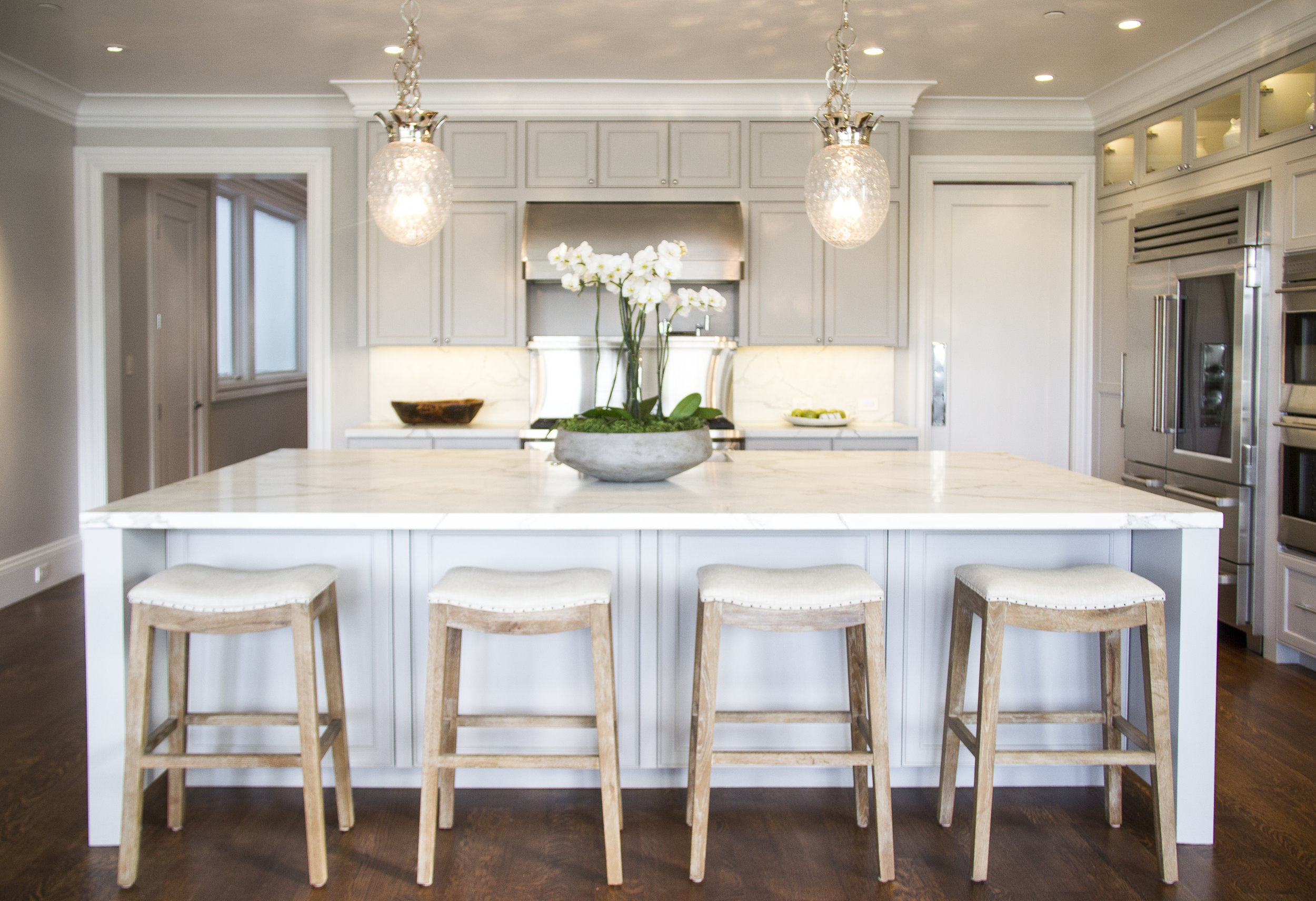 white, kitchen, marble counters, barstools, hardwood floor, chandelier, cabinets, stainless steel, open kitchen, clean, light 
