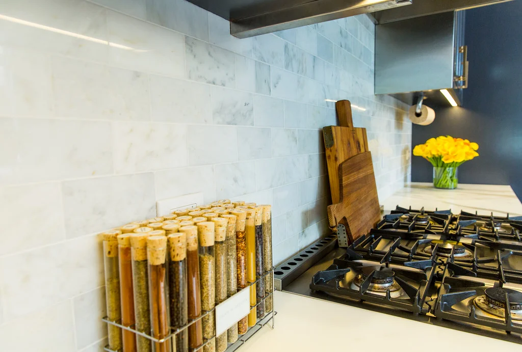 marble subway tile, marble counters, kitchen, spice rack, range, stove top, cutting boards