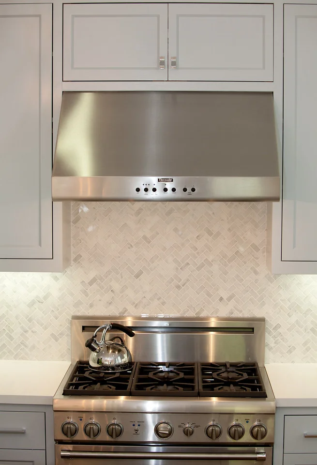 stainless steel, stove, herringbone backsplash, marble backsplash, kitchen, marble counters