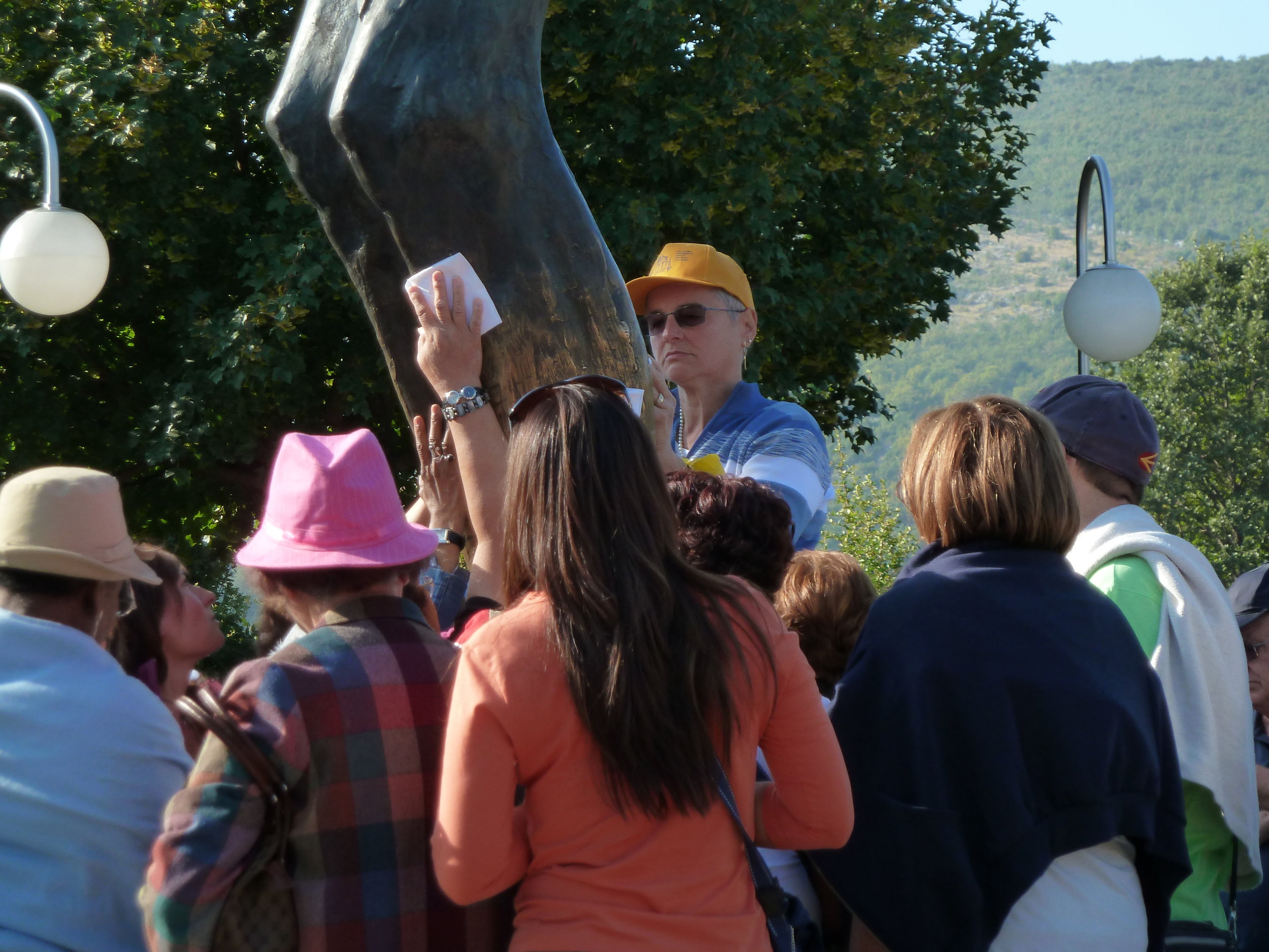 Tourists examining the "weeping knee" of the Risen Christ statue, Medugorje, Hercegovina