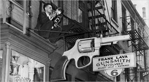 Weegee perched on a fire escape, New York. Photo by Leigh Wiener.